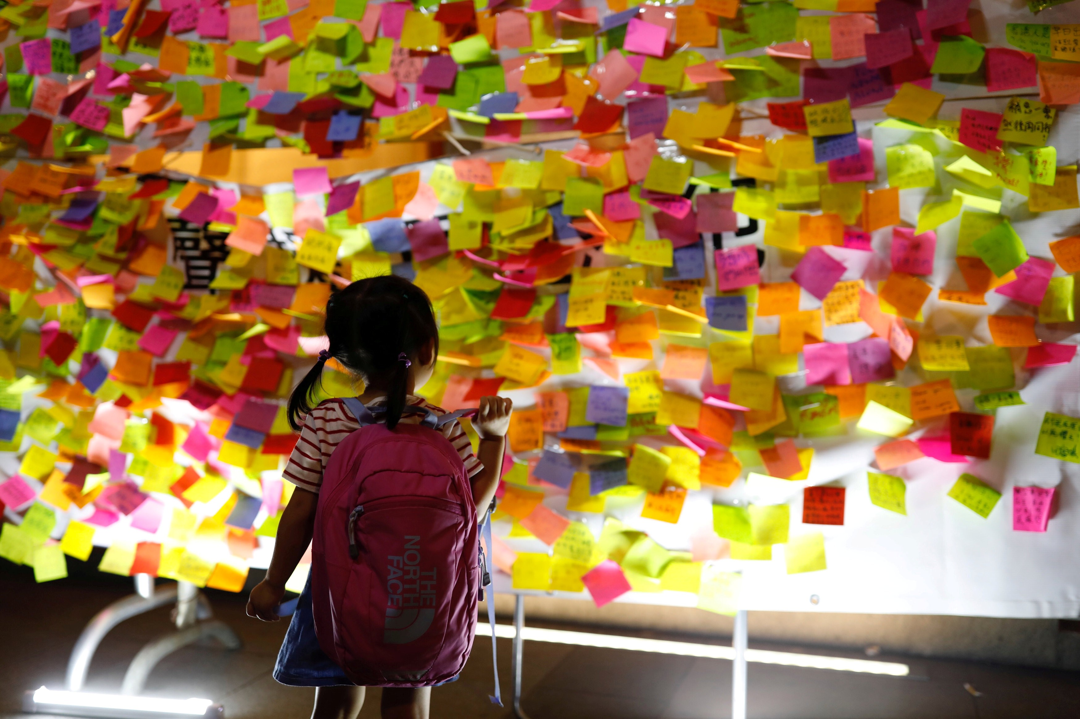 A child looks at messages in support of jailed pro-democracy leaders Joshua Wong Chi-fung, Nathan Law Kwun-chung and Alex Chow Yong-kang, posted on a wall during a protest rally in Hong Kong on August 20. Photo: Reuters