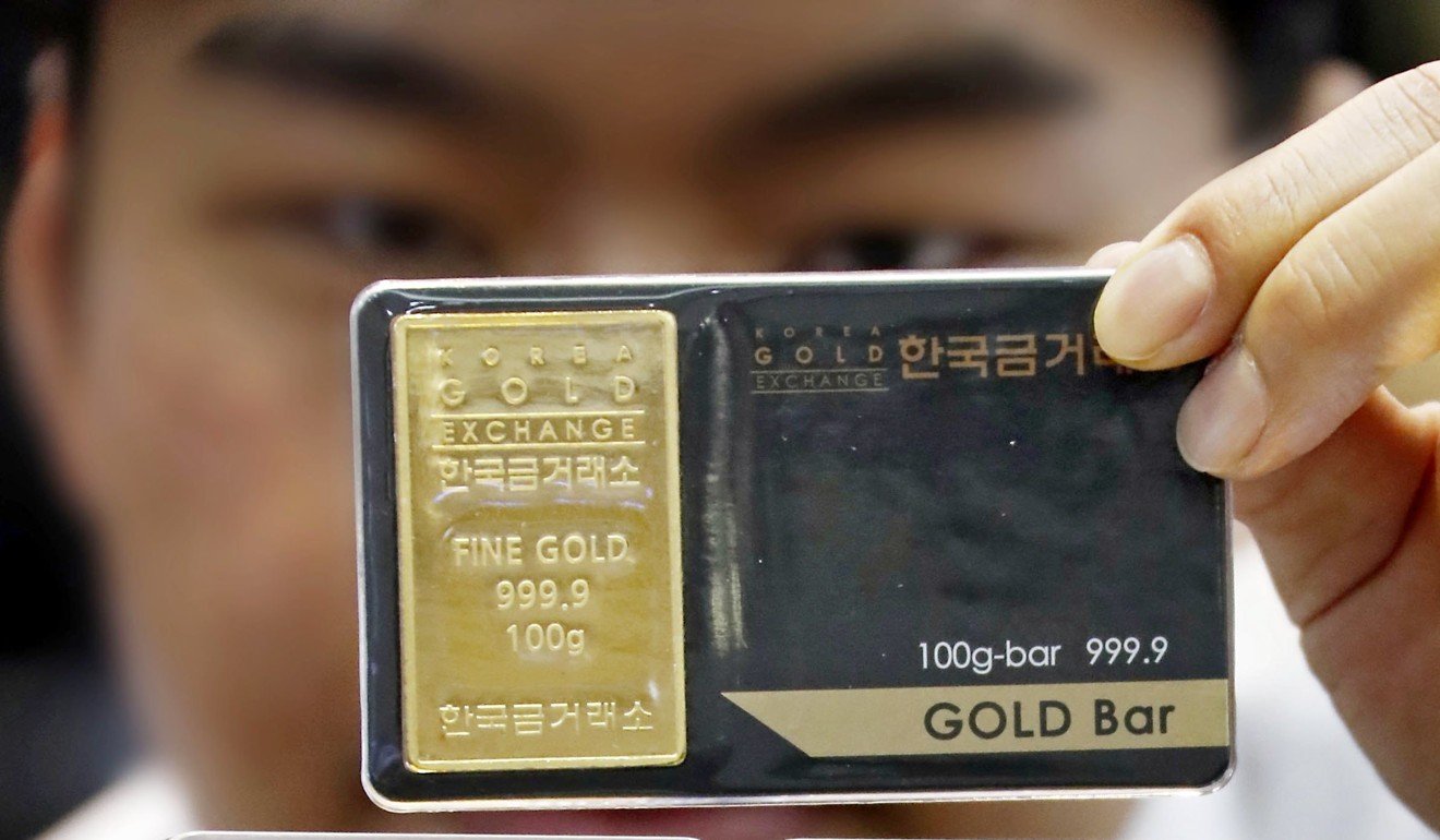 An official at the Korea Gold Exchange displays gold bars in Seoul. Photo: EPA