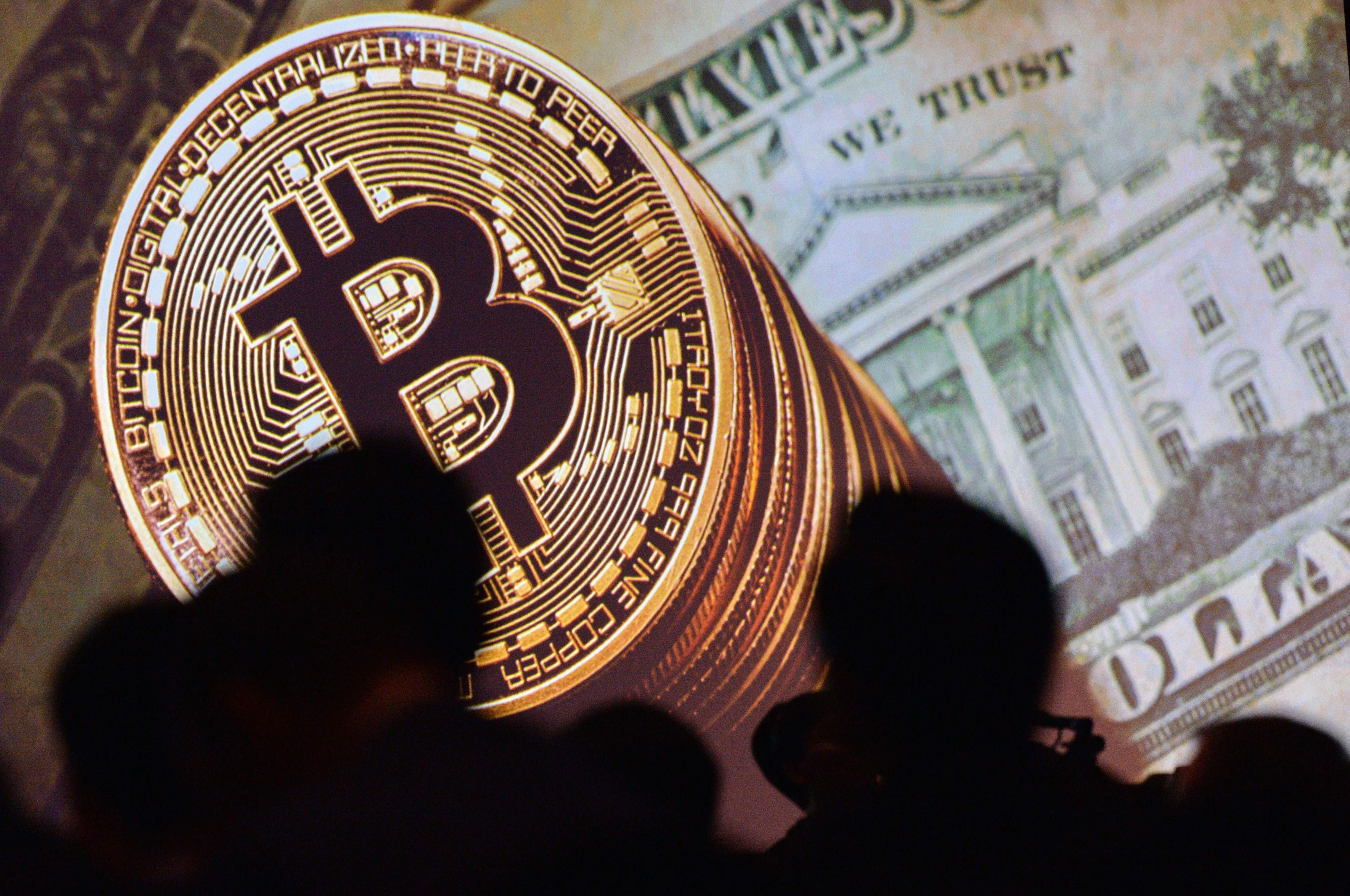 Bitcoin and the US currency are displayed on a screen as delegates listen to a panel during the Interpol World Congress in Singapore on July 4. The price of bitcoin versus the US dollar has gone up over 330 times. Photo: AFP