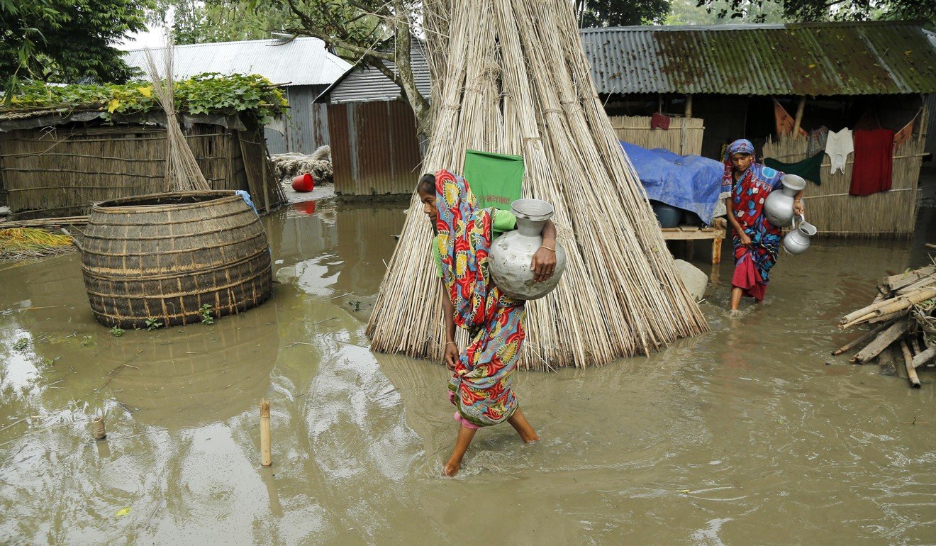 Flood victims return to temporary shelters after collecting drinking water in Bogra district, Bangladesh, on August 16. Photo: EPA