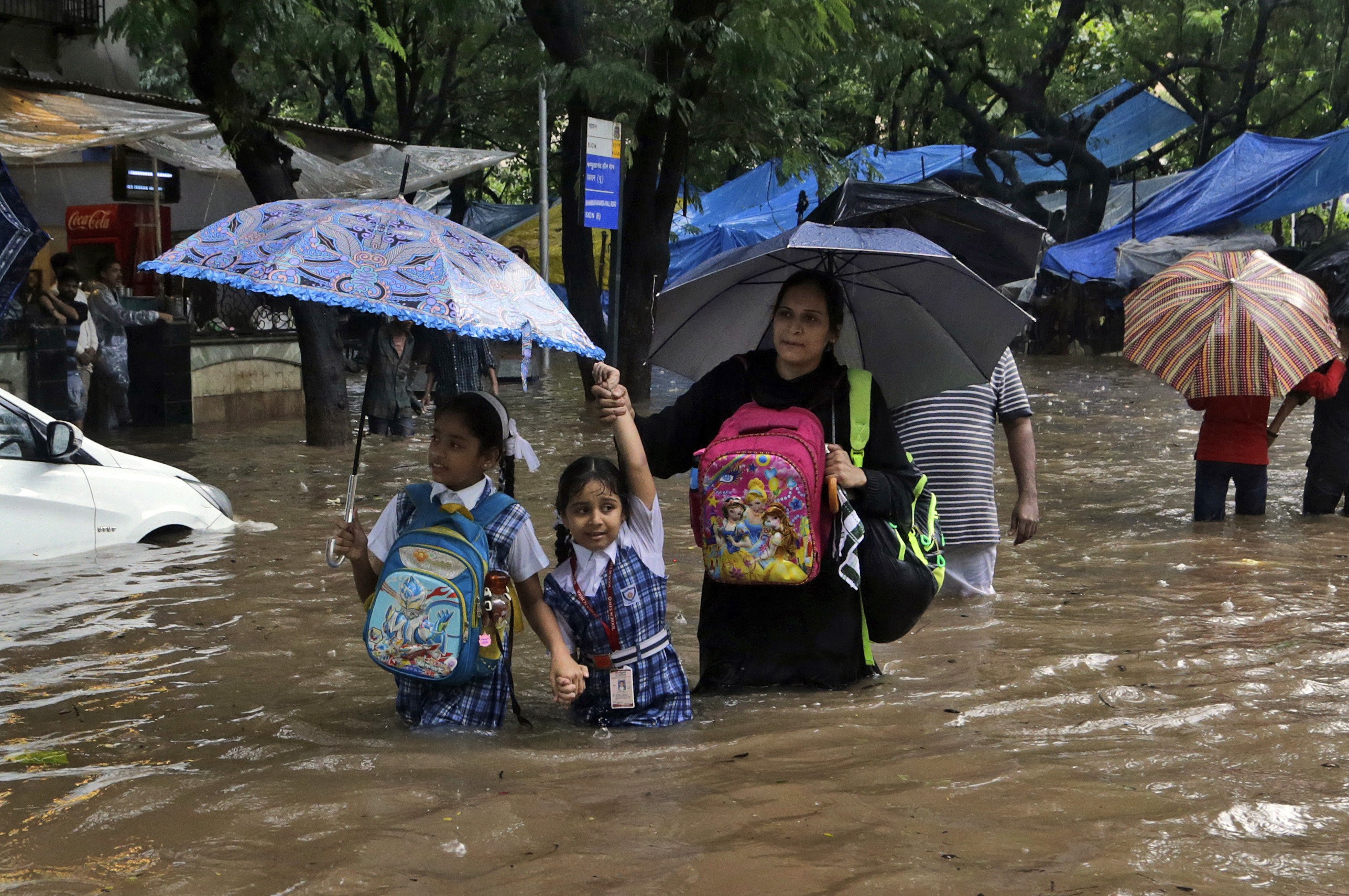 Families wade through floods in Mumbai on August 29. Mumbai was especially hard hit, with water swamping offices, schools and roads, and some 60 people killed. Photo: AP