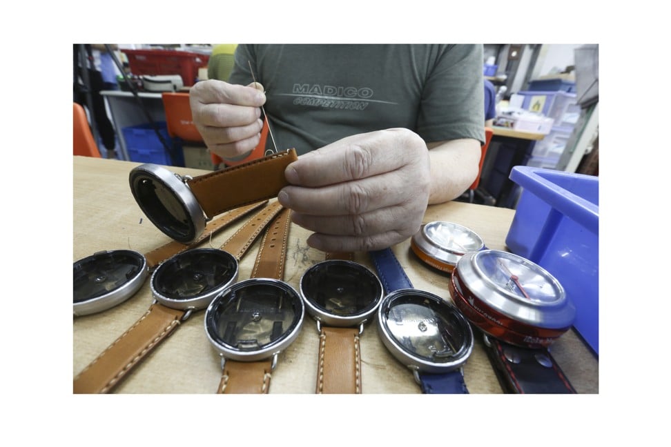 A worker sews the recycled leather strap of one of Alchemist Creations’ watches. Photo: Jonathan Wong