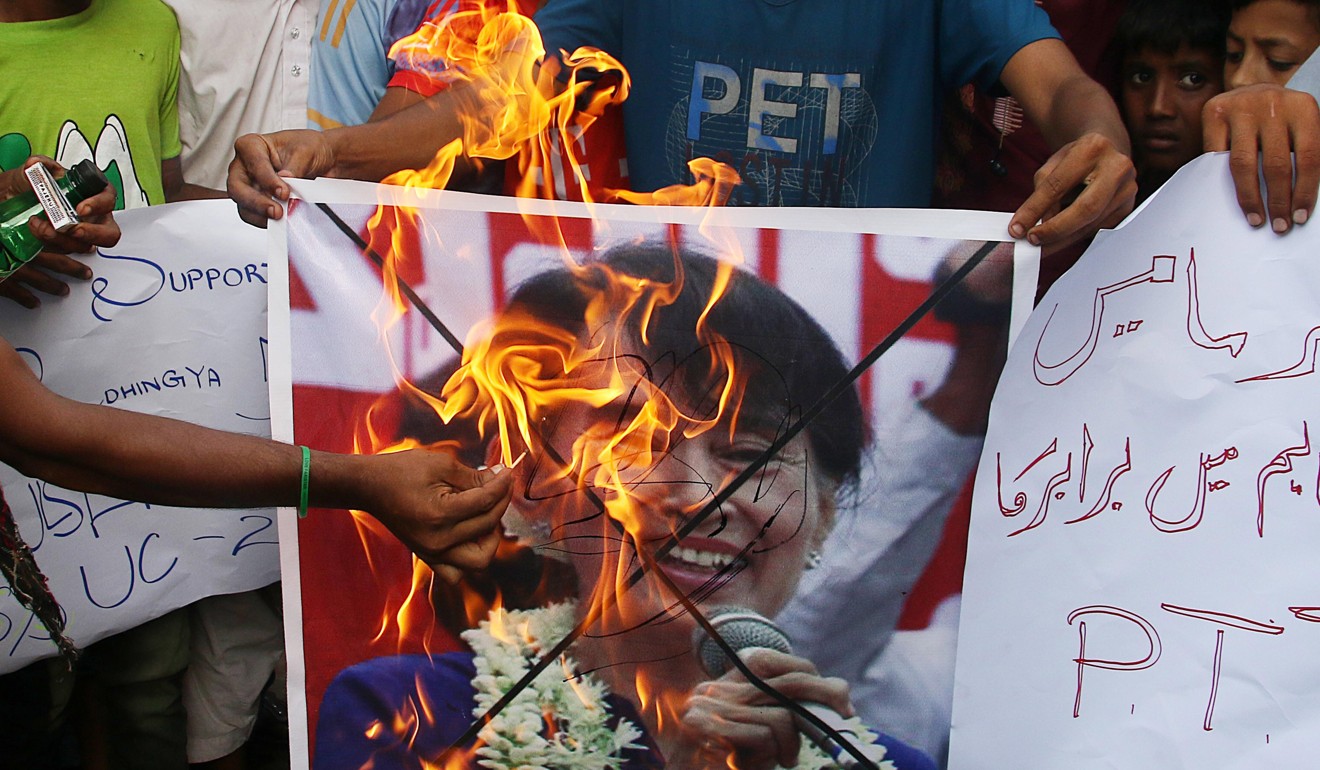 People burn a picture of Myanmar leader Aung San Suu Kyi. Photo: EPA