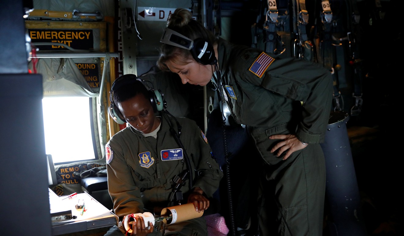 US Air Force Reserve Technical Sergeant Karen Moore and Major Nicole Mitchell look at a dropsonde, a device dropped from planes to monitor meteorological data in a hurricane. Photo: Reuters