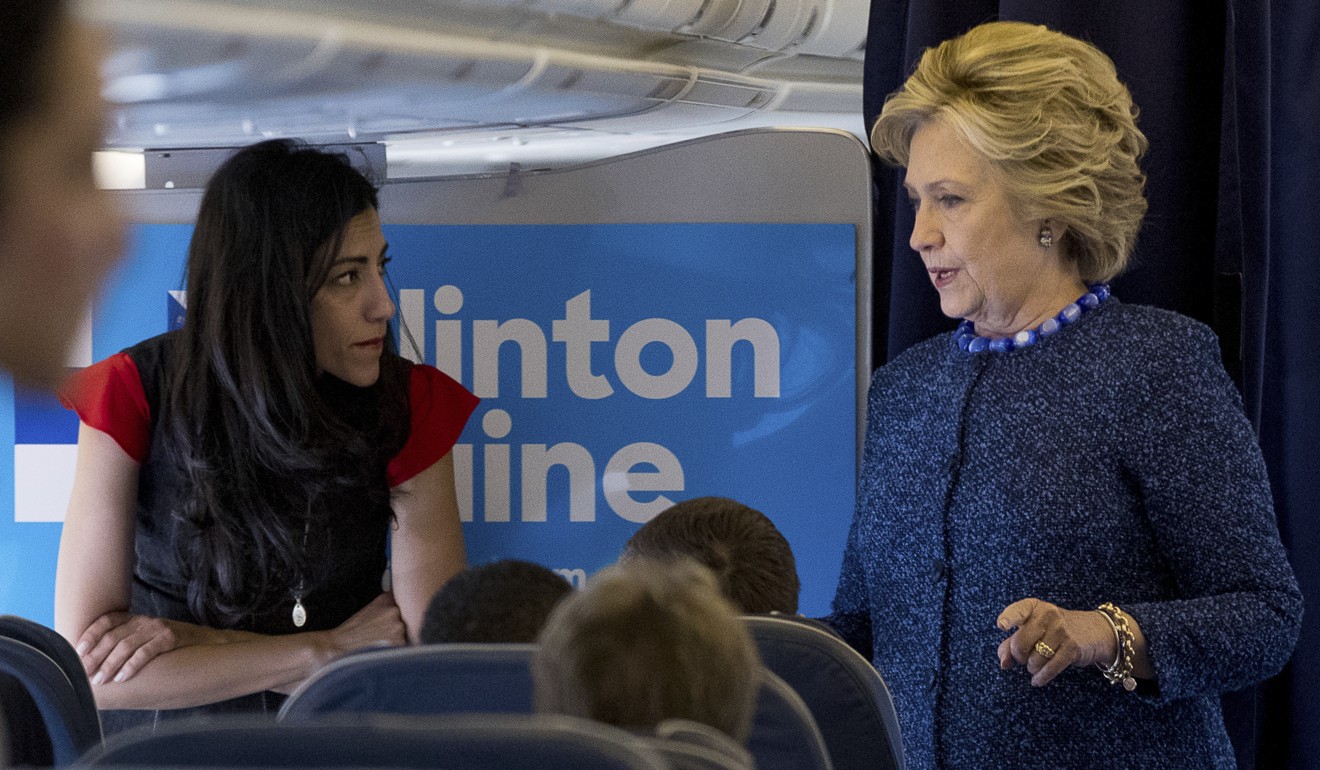 Aboard her presidential campaign plane, Hillary Clinton speaks with senior aide Huma Abedin. Photo: AP