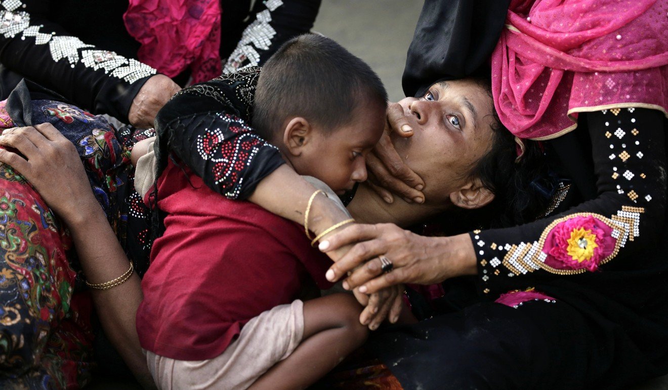 Rohingya woman Anowara Begum holds her son after she fainted soon after disembarking from a boat that crossed the Naf river and landed in Teknaf, Bangladesh. Photo: EPA-EFE