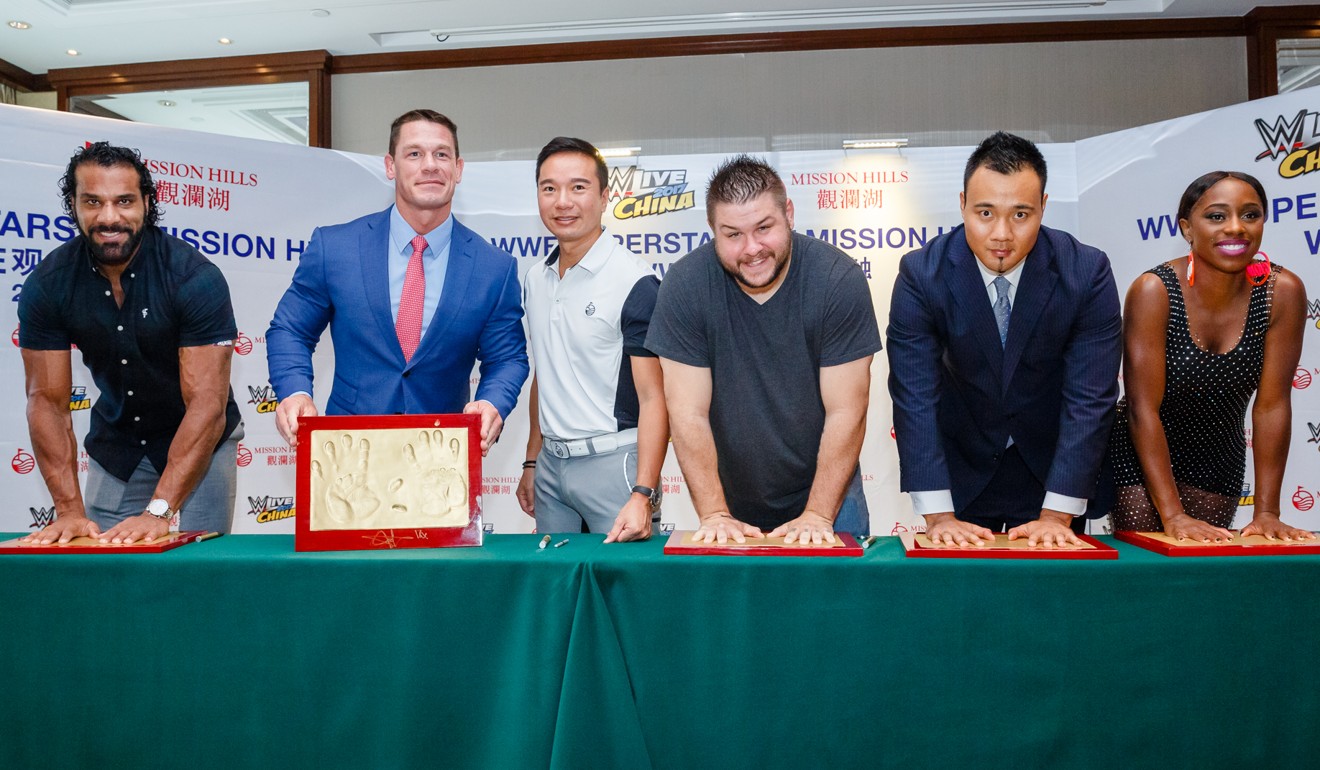 WWE stars (from left) Jinder Mahal, John Cena, MiKevin Owens, Tian Bing and Naomi make hand prints with Mission Hills vice-chairman Tenniel Chu. Photo: WWE