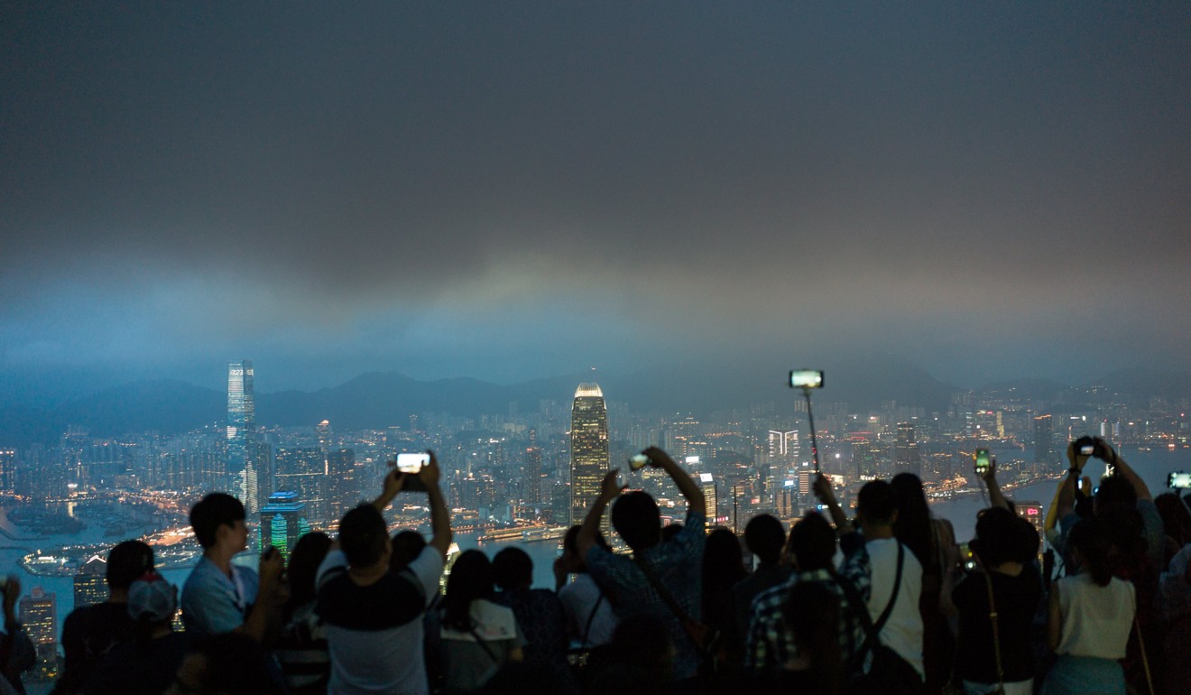 Tourists on Victoria Peak in Hong Kong. Political strife, generational division and financial uncertainty are consuming public discourse in the city. Photo: EPA