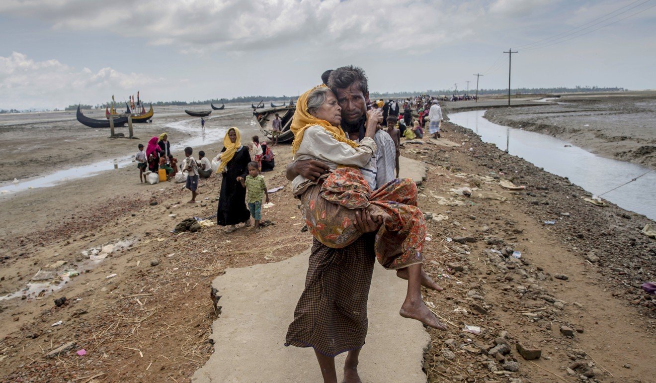 A Rohingya Muslim man carries his mother to a refugee camp after crossing over from Myanmar into Bangladesh. Photo: AP
