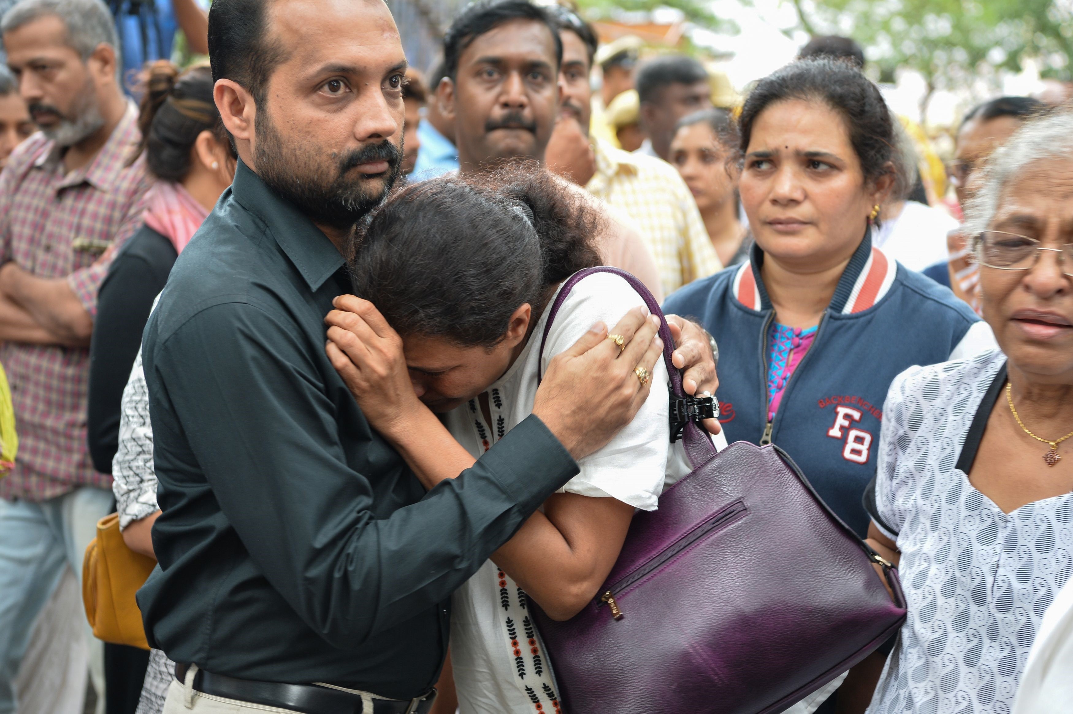 Indian journalist Gauri Lankesh's sister Kavitha Lankesh is consoled by a relative as her body is brought to the Ravindra Kalakshetra cultural centre in Bangalore. Photo: AFP