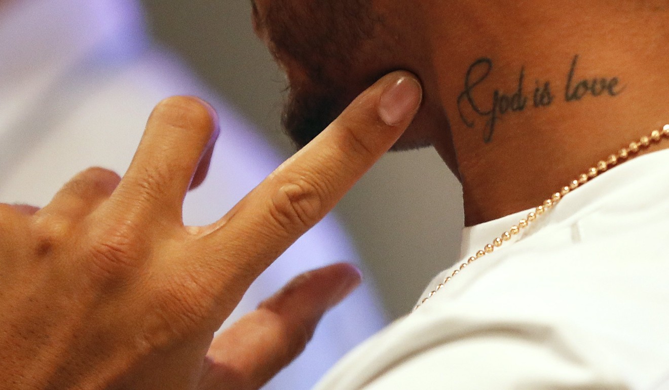 Lewis Hamilton shows his ‘God is love’ tattoo during a press conference in Kuala Lumpur. Photo: EPA