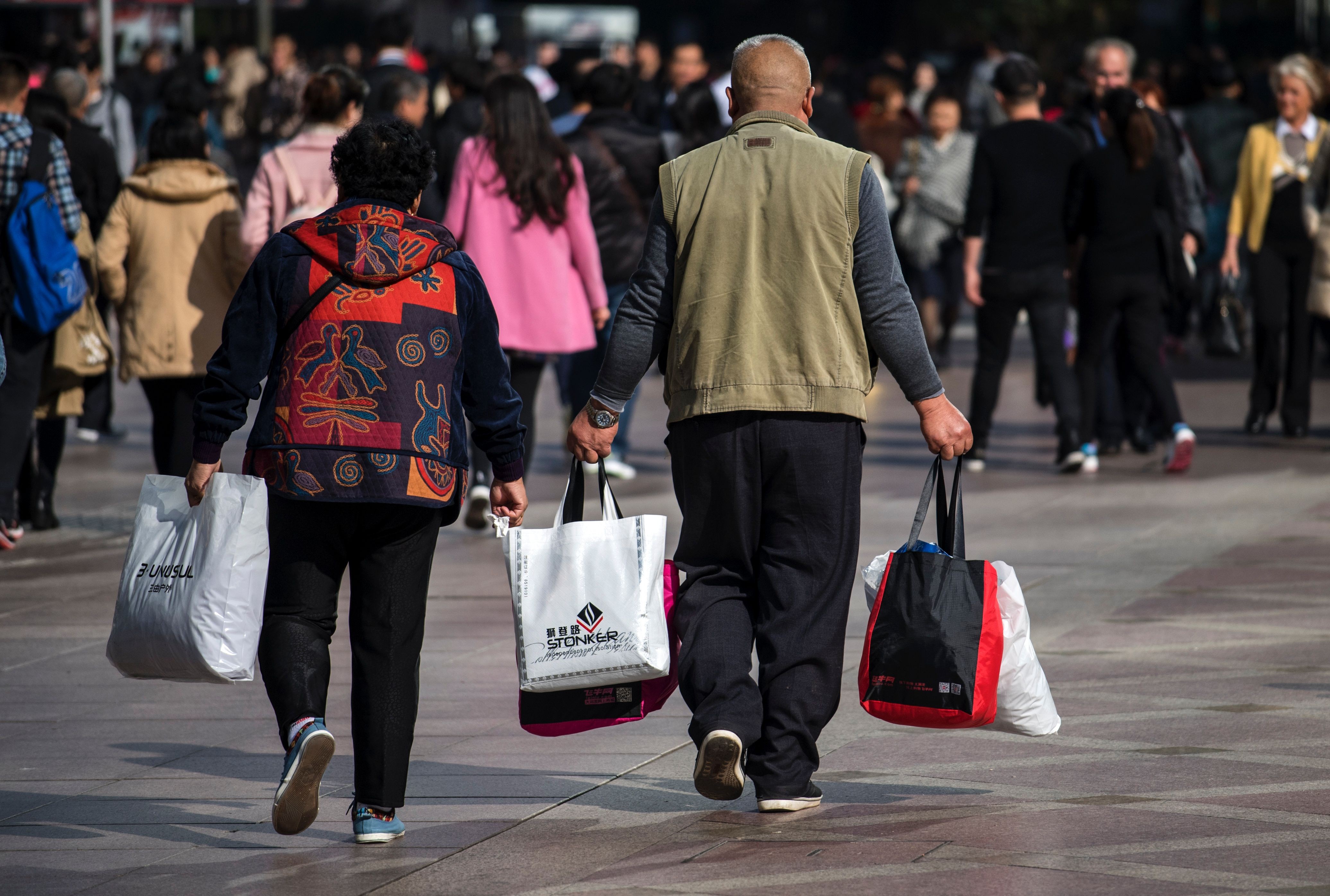 A couple carry bags along the main shopping street in Shanghai last November. More market rather than less is key to sustaining China’s economic growth in the long term. Photo: AFP