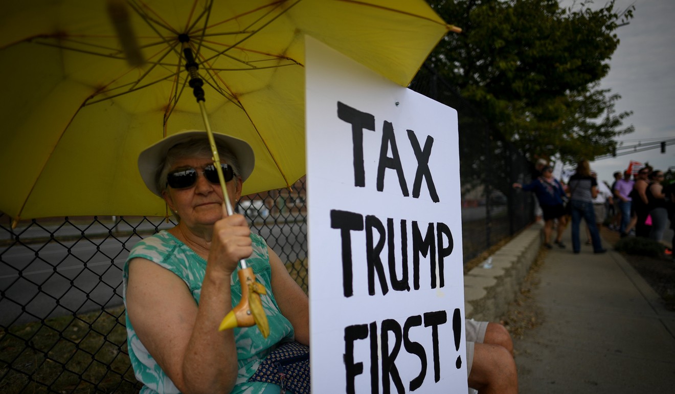 Virginia Shaka, 62, holds a sign during demonstrations as Donald Trump delivers a speech on tax reform at the Indiana State Fairgrounds in Indianapolis on Wednesday. Photo: Reuters