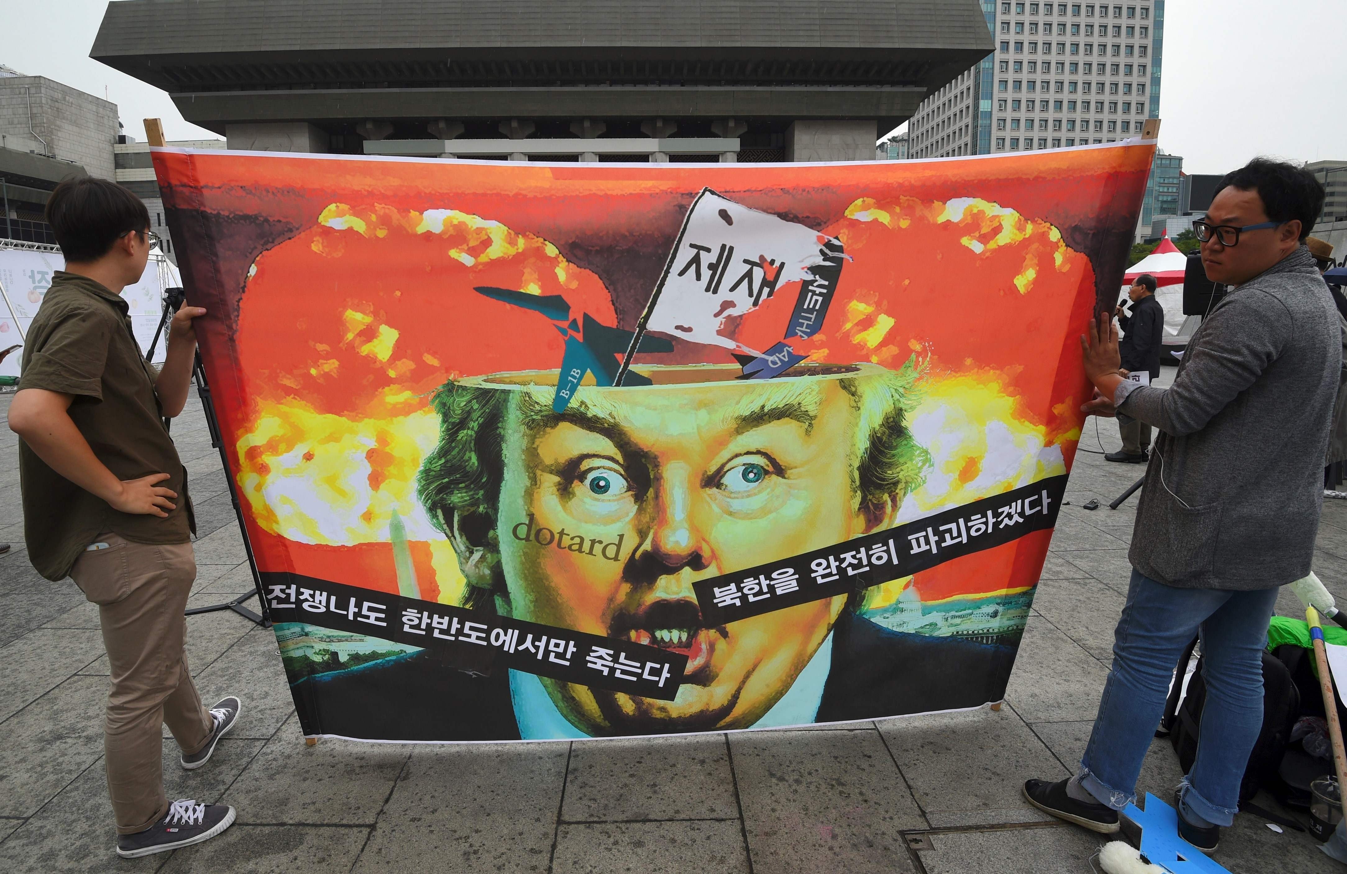 Anti-war activists hold a banner showing a caricature of US President Donald Trump during a rally near the US embassy in Seoul on September 27. Part of the banner reads, “If war breaks out, only those on the Korean peninsula will die”. Photo: AFP
