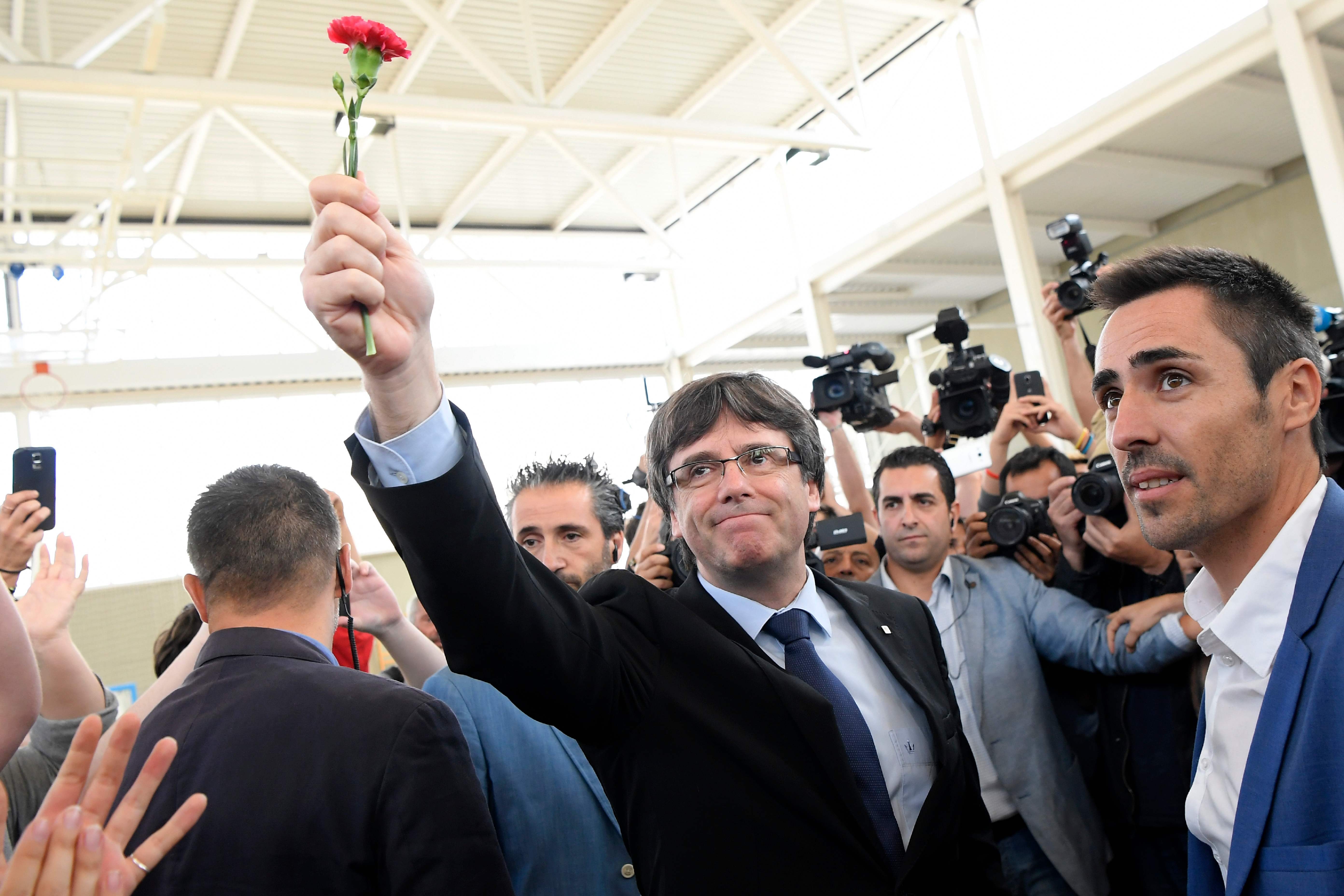 Catalan leader Carles Puigdemont holds a carnation in Sant Julia de Ramis on Sunday during the referendum on independence for Catalonia that was banned by Madrid. Photo: AFP