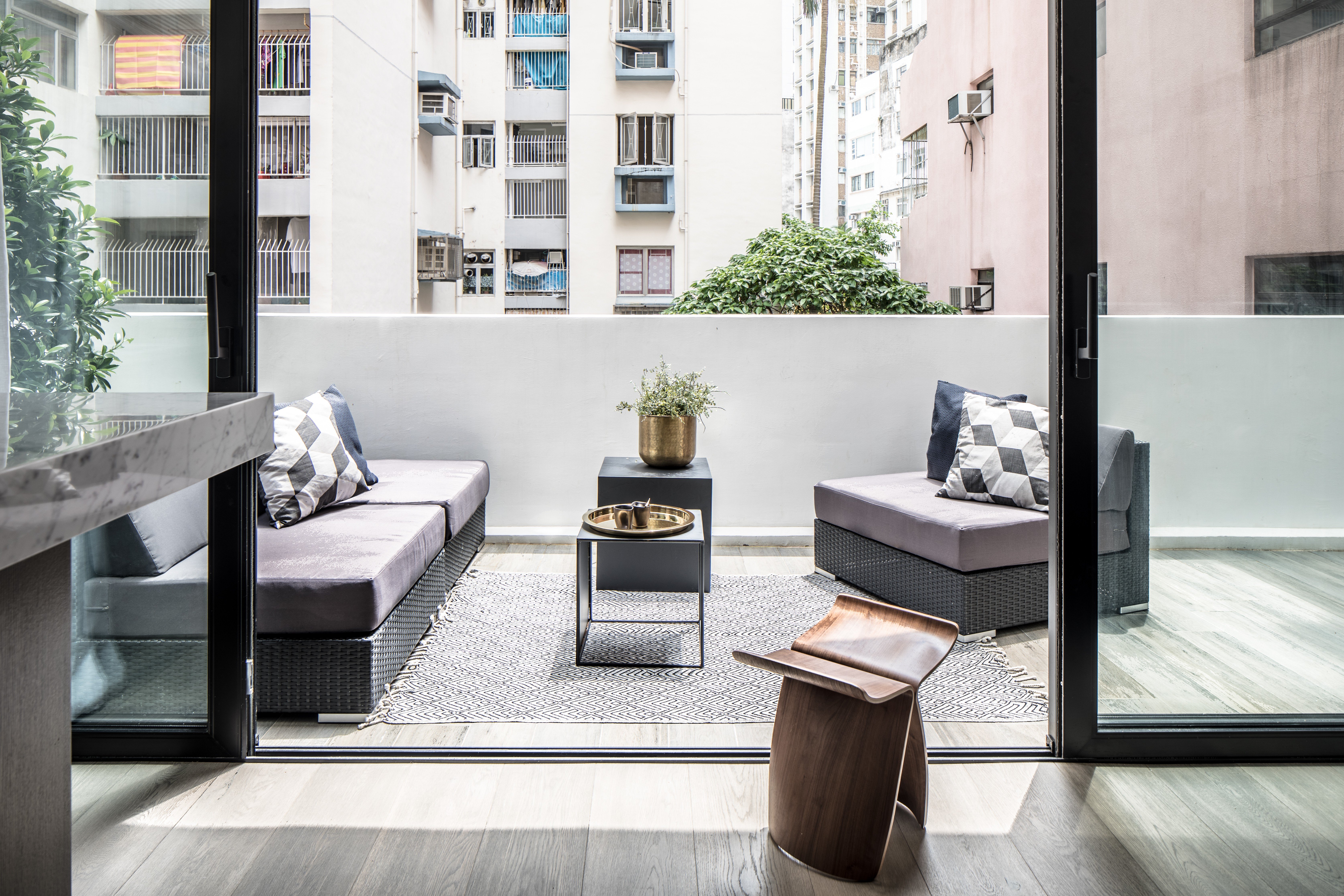 Clever details such as glass doors and internal windows have helped turn a poky flat into a light-filled apartment in which the spacious wraparound terrace becomes a natural extension of the interior
