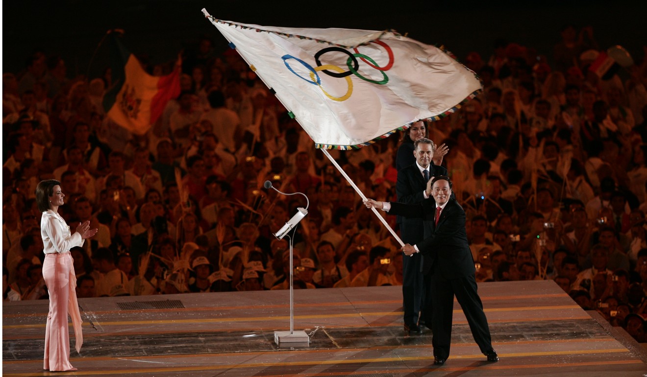Beijing mayor Wang Qishan waves the Olympic flag after accepting it at the closing ceremony of the Athens Olympic Games in August 2004. Photo: Xinhua