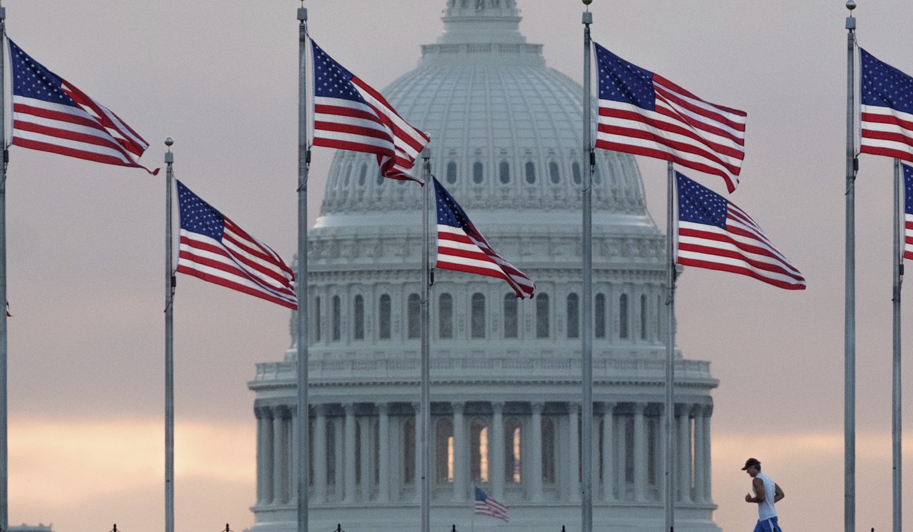 An early morning runner crosses in front of the US Capitol as he passes the flags circling the Washington Monument. The wealth gap between white Americans and the rest of the nation is increasing. Photo: AP