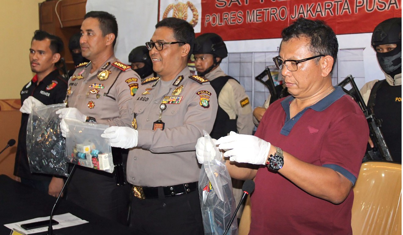 Police officers displaying evidence collected during the raid. Photo: AFP