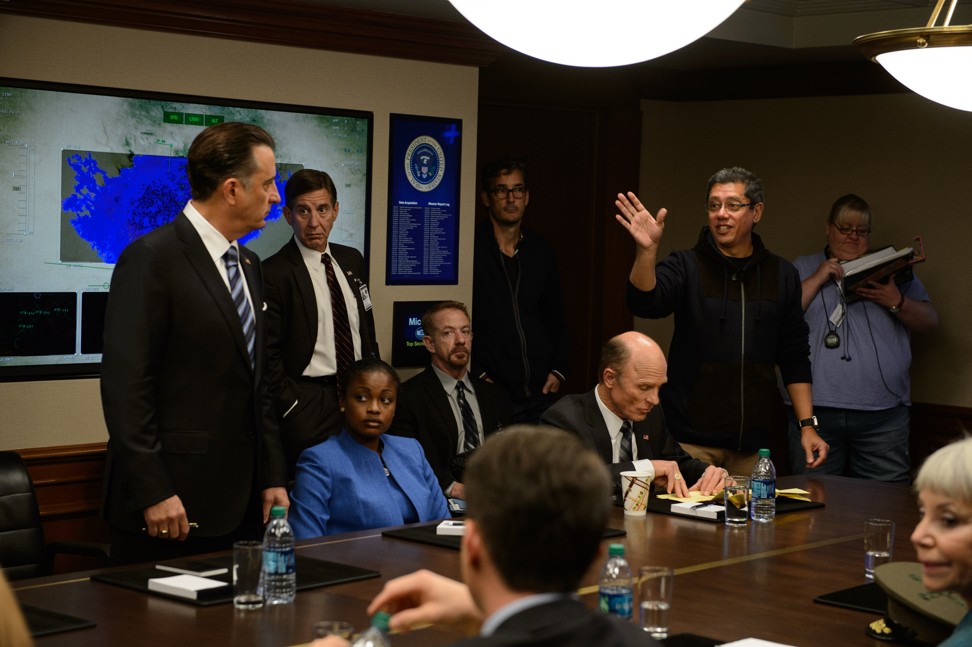 Andy Garcia (left), as the US president, listens to the instructions of director Dean Devlin (second right) on the set of Geostorm.