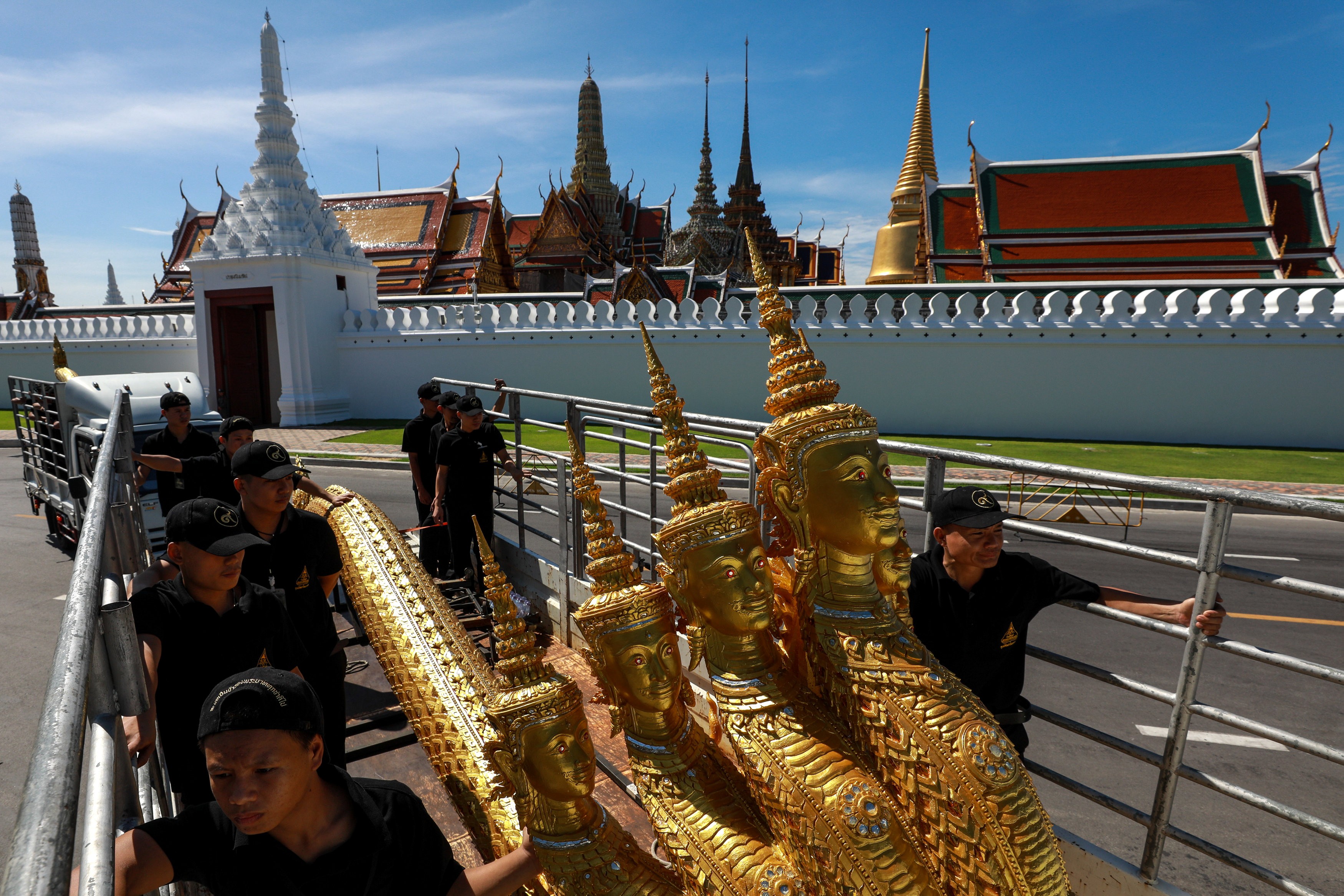 Workers move deity sculptures which will be used during the late king’s funeral. Photo: Reuters