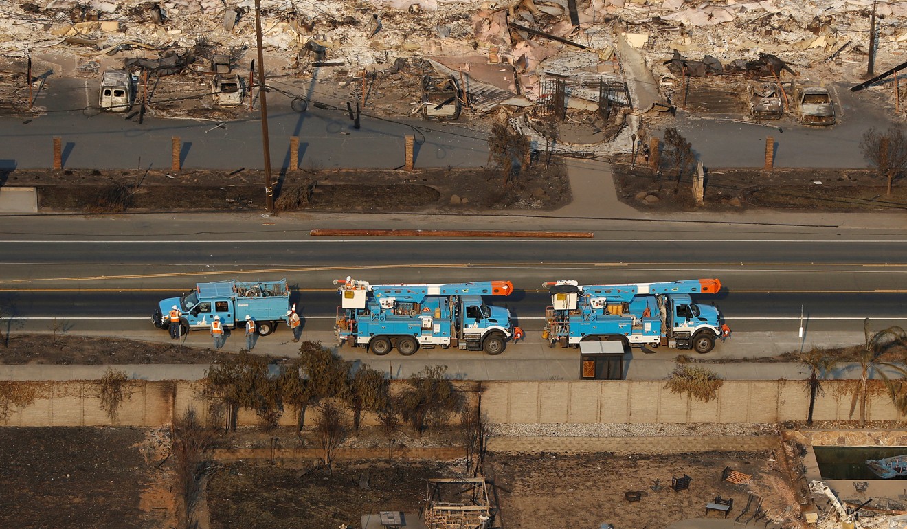 Pacific Gas and Electric trucks on a road between homes destroyed by the fire in Santa Rosa, California. Photo: Reuters