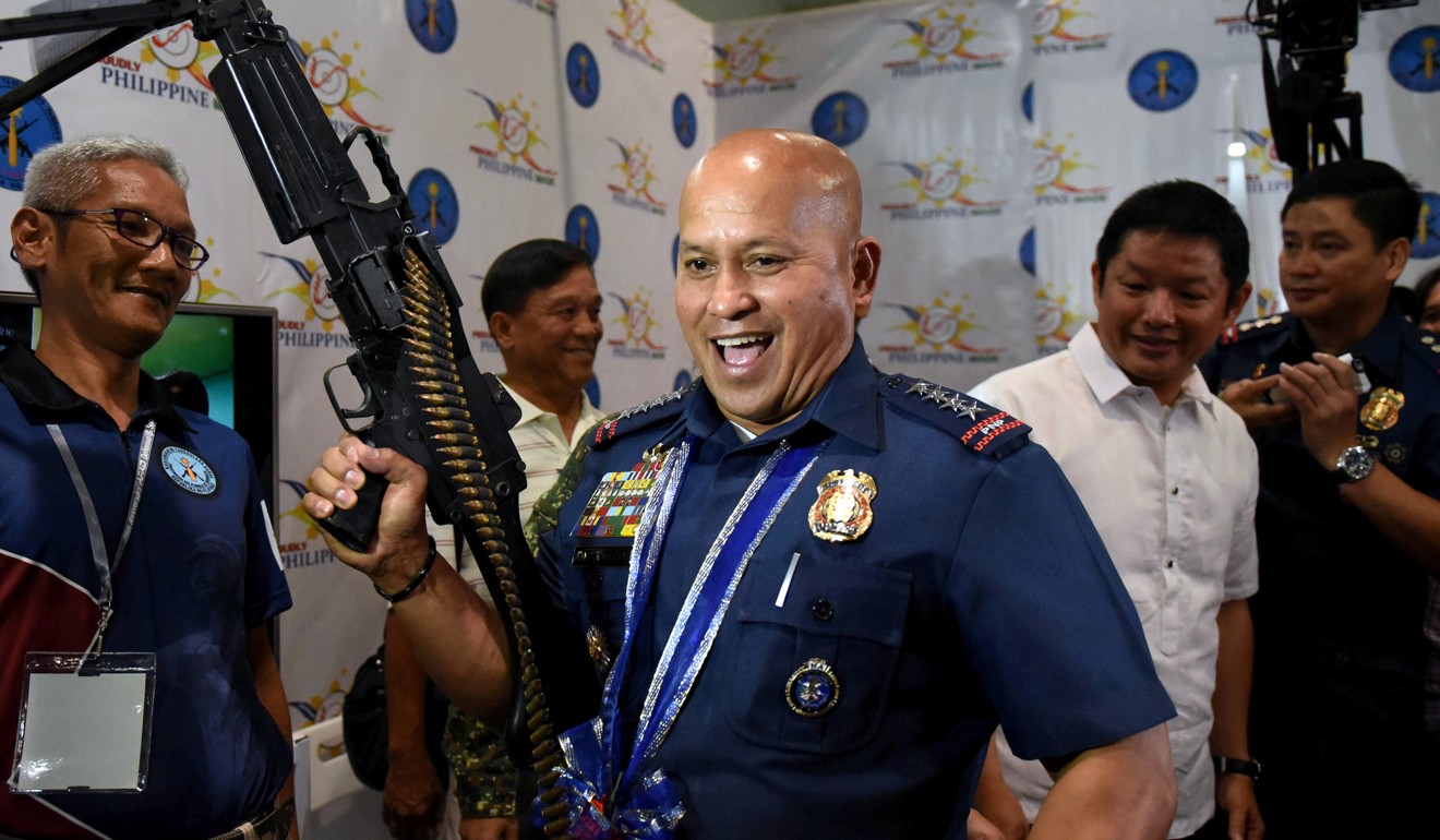 Ronald Dela Rosa holds an M60 machine gun at a gun show in Manila in July. Photo: Reuters