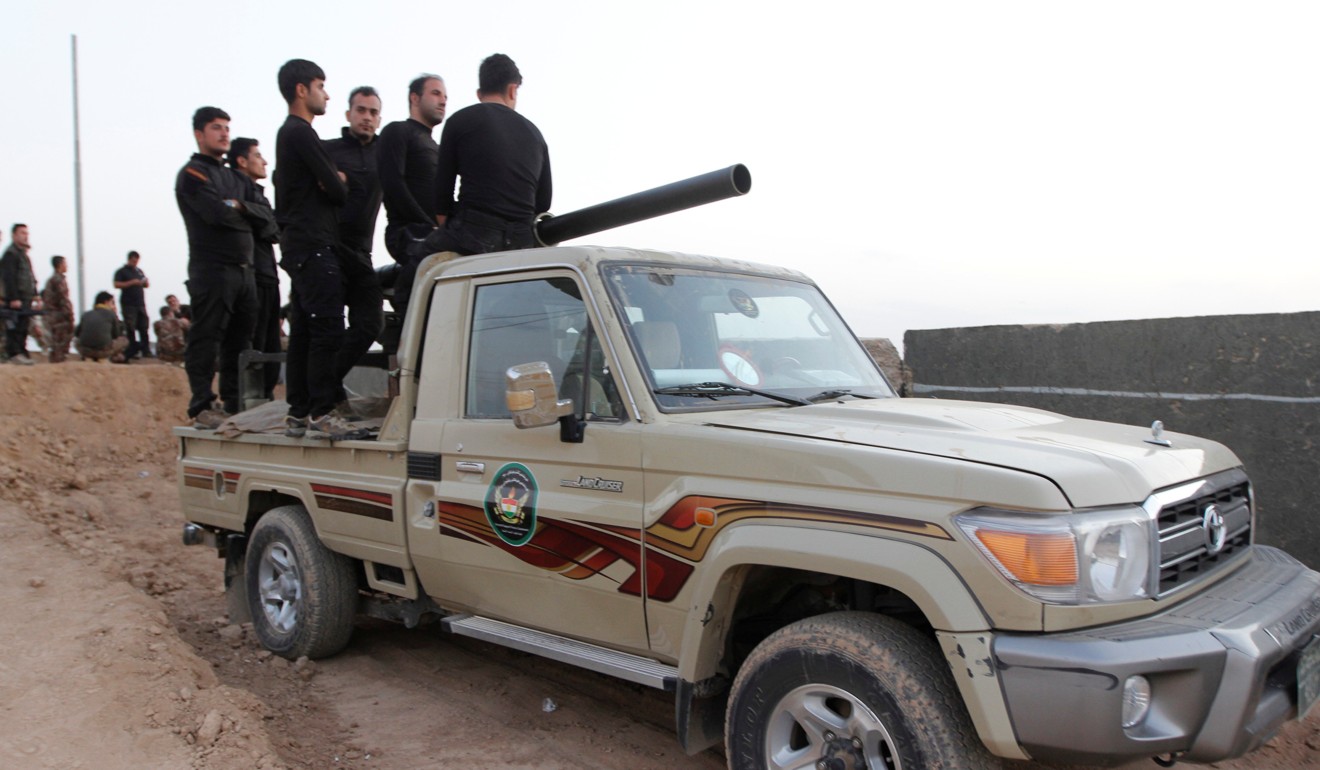 Kurdish Peshmerga fighters ride in a vehicle in the southwest of Kirkuk. Photo: Reuters