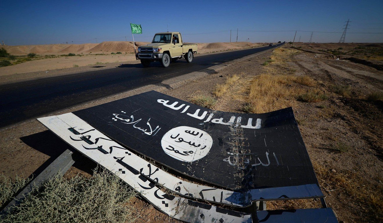 A black sign belonging to Islamic State militants is seen on the road in Al-Al-Fateha military airport south of Hawija, Iraq. Photo: Reuters