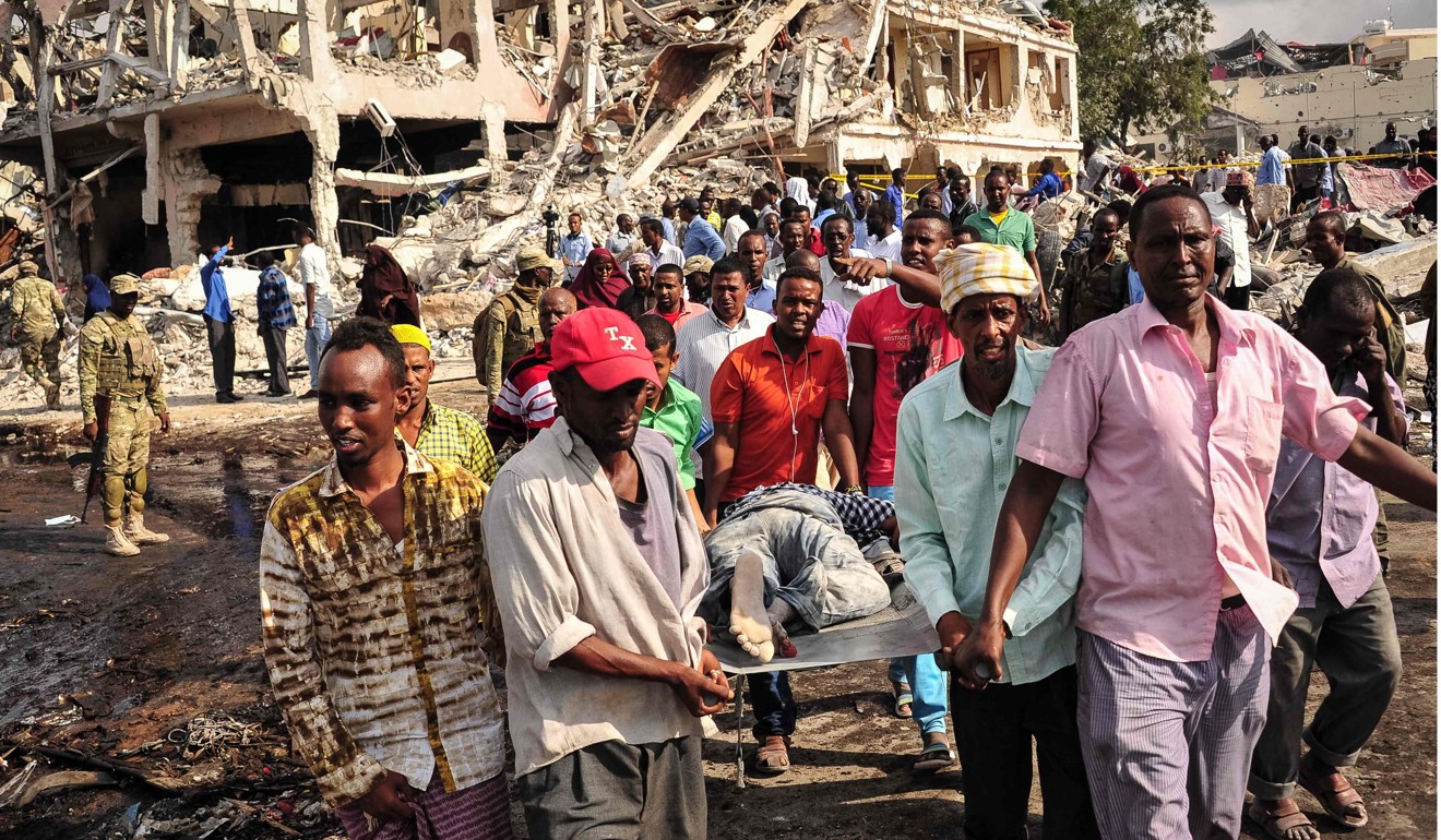 Somali men carry the body of a victim who died in the explosion in Mogadishu, on Saturday. Photo: Agence France-Presse