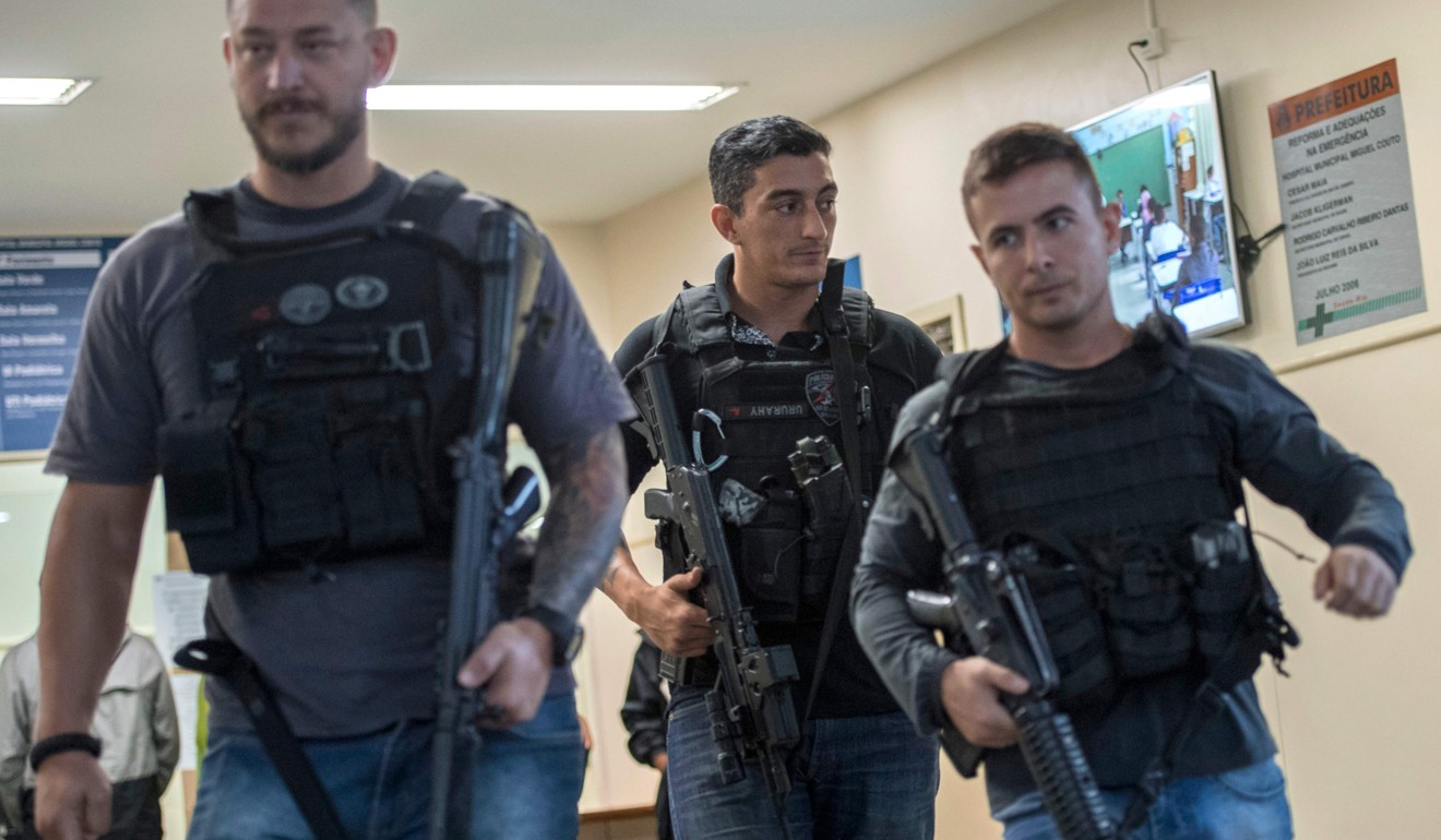 Police officers walk in the entrance of the Miguel Couto Hospital where the Spanish tourist Maria Esperanza was taken after being shot dead by police while visiting Rocinha favela in Rio de Janeiro on Monday. Photo: Agence France-Presse