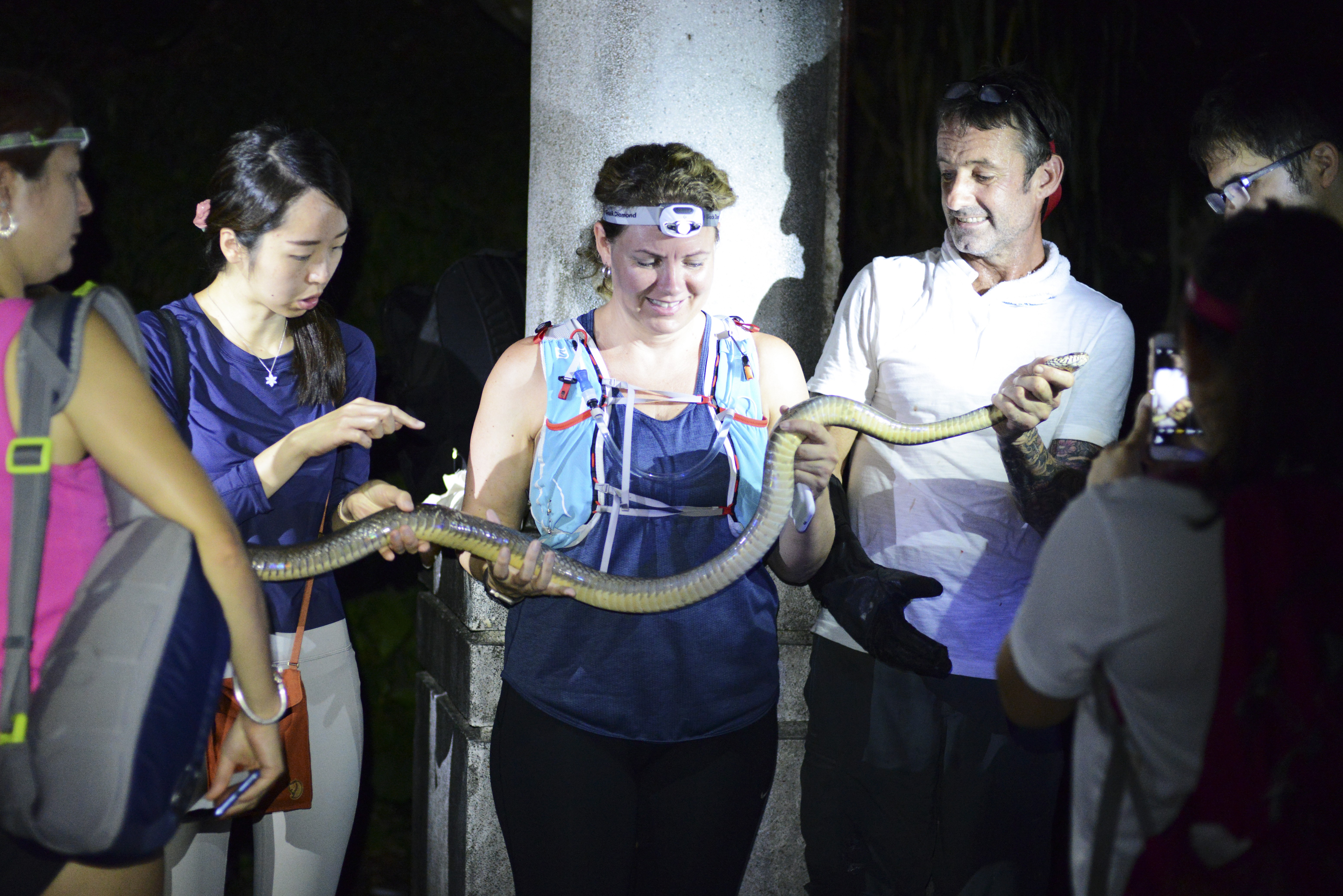 Dave Willott (in white T-shirt) and snake safari guests handle a common rat snake. in Hong Kong. Photo: Red Door News