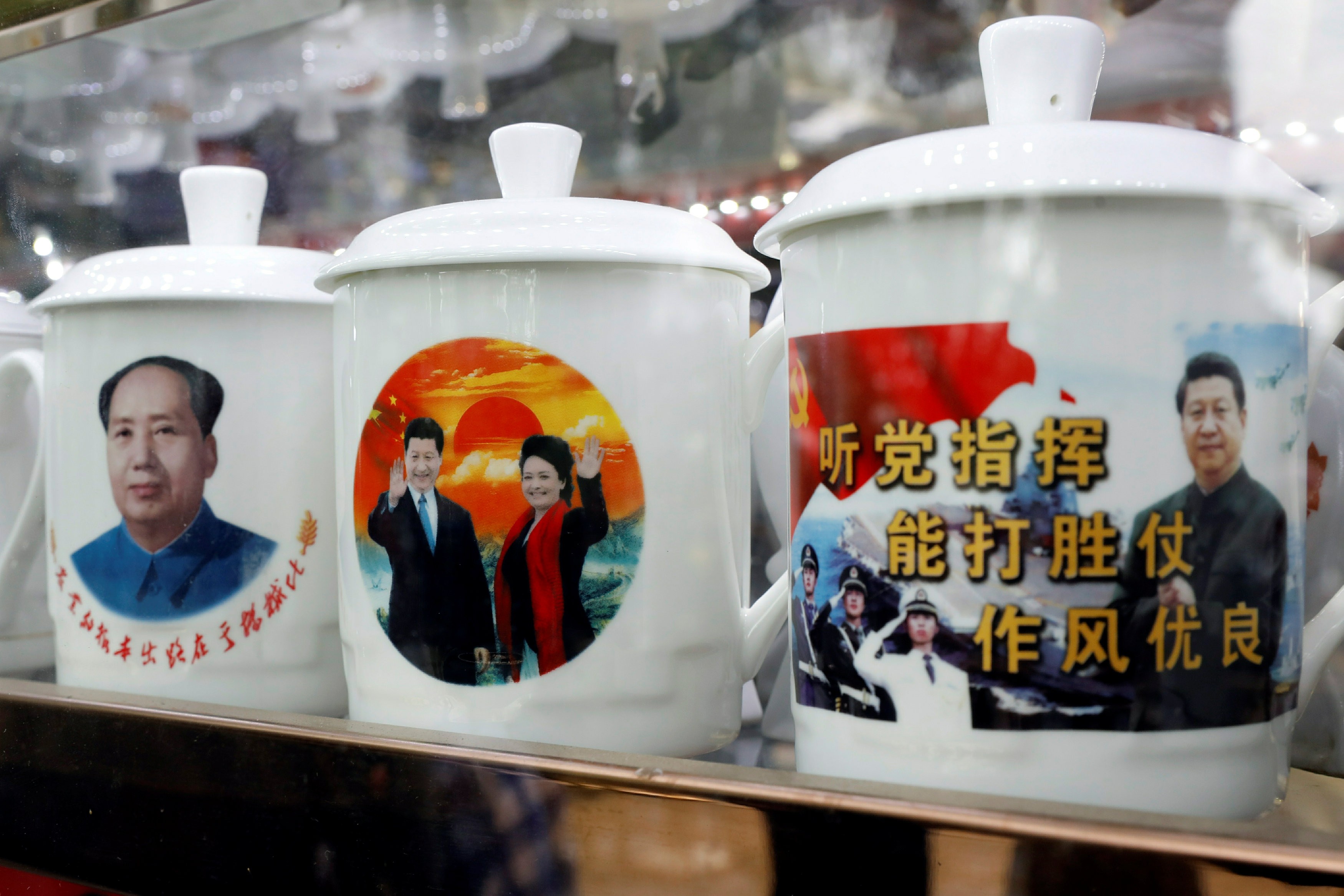 Souvenir cups with images of Chairman Mao Zedong and Chinese President Xi Jinping on sale during the Communist Party’s 19th National Congress. Photo: Reuters