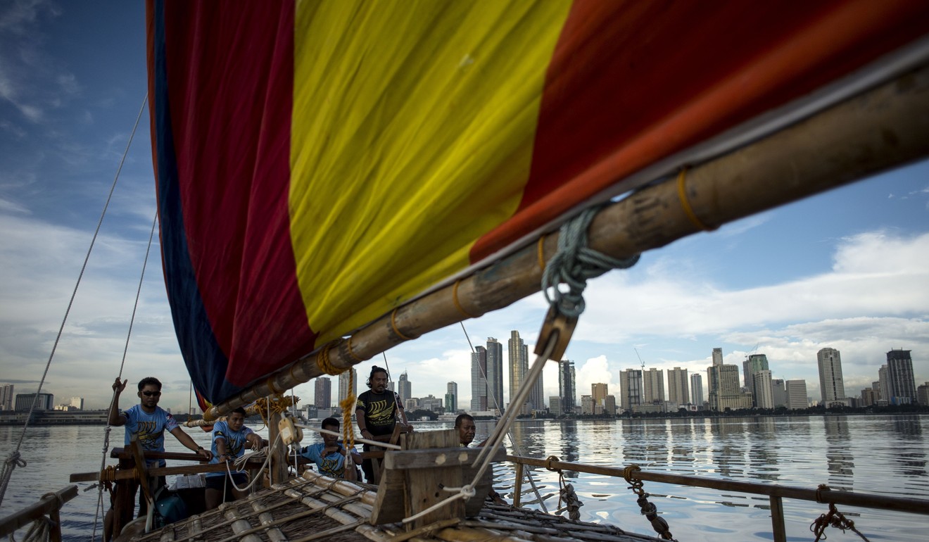Deckhands aboard a traditional Philippine wooden boat known as balangay sailing on their craft in Manila Bay. Photo: AFP