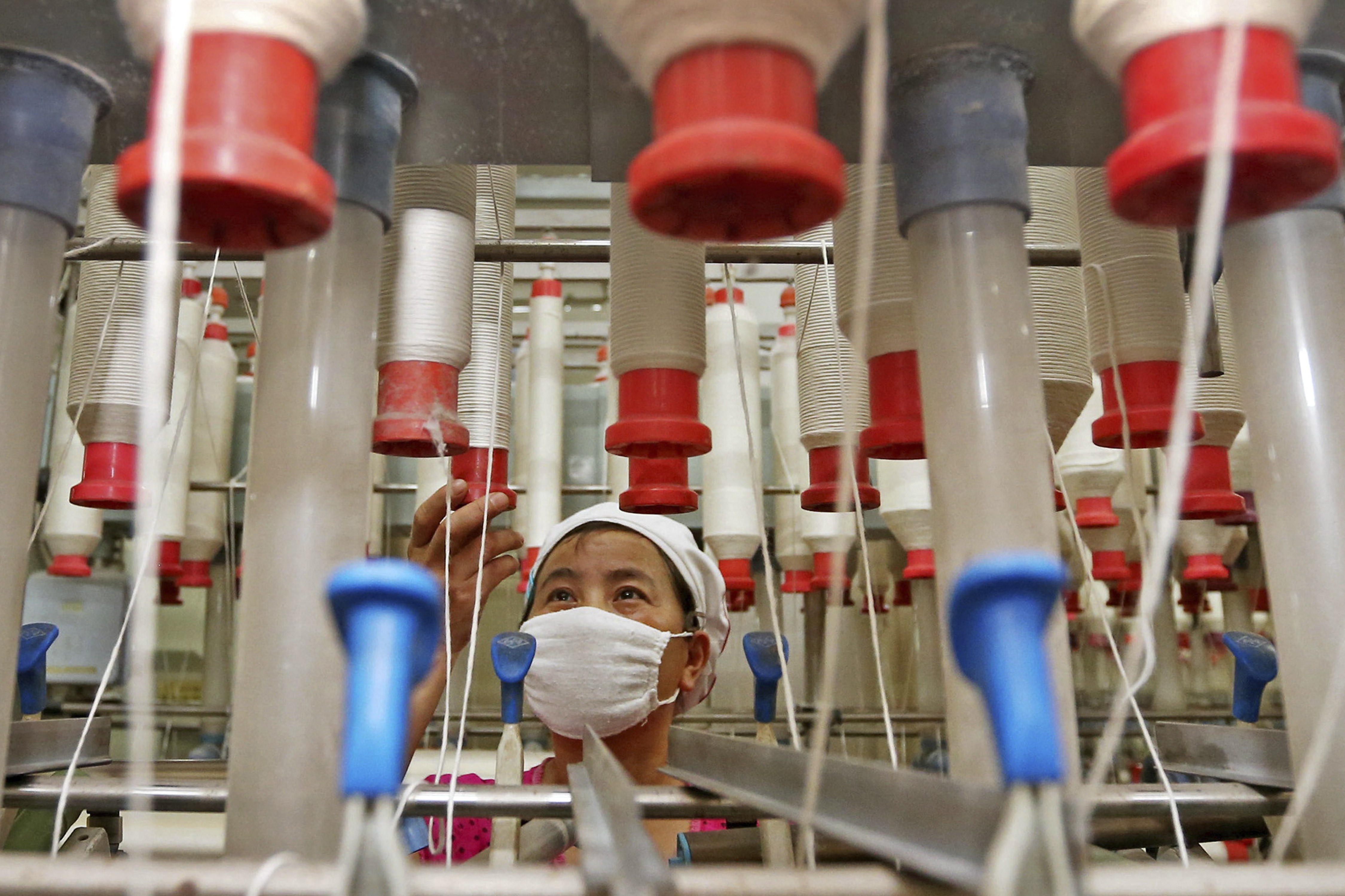 A worker checks cotton thread barrels in a textile factory in Huaibei, Anhui province, one of the major sources of migrant workers to the more prosperous and developing parts of China, such as the Pearl River Delta. But rising wages, increased reliance on automation and changing technology may put their jobs on the line. Photo: AP