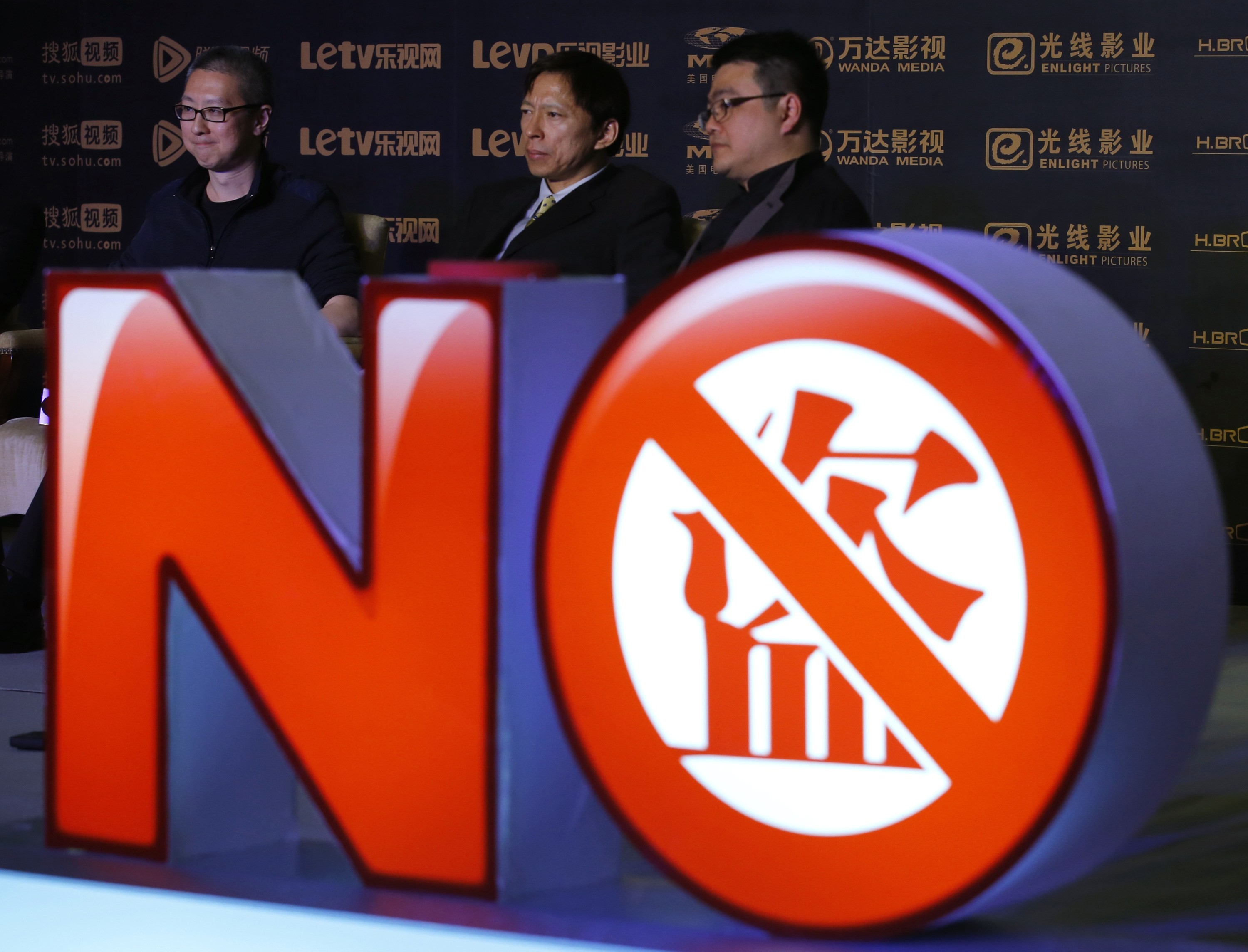 Victor Koo, CEO of Youku Tudou (left), Sohu CEO Charles Zhang (centre) and Tencent senior vice-president Seng Yee Lau stand behind a sign symbolising action against copyright violation during a news conference in Beijing in 2013. Online piracy and copyright violation is an ongoing problem in Asia. Photo: Reuters