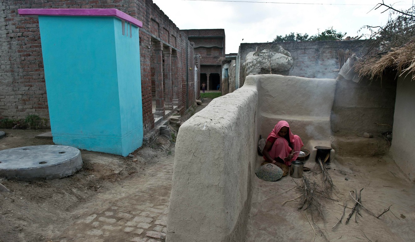 A villager cooks breakfast near a new toilet in Katra Sahadatgunj. Photo: AFP