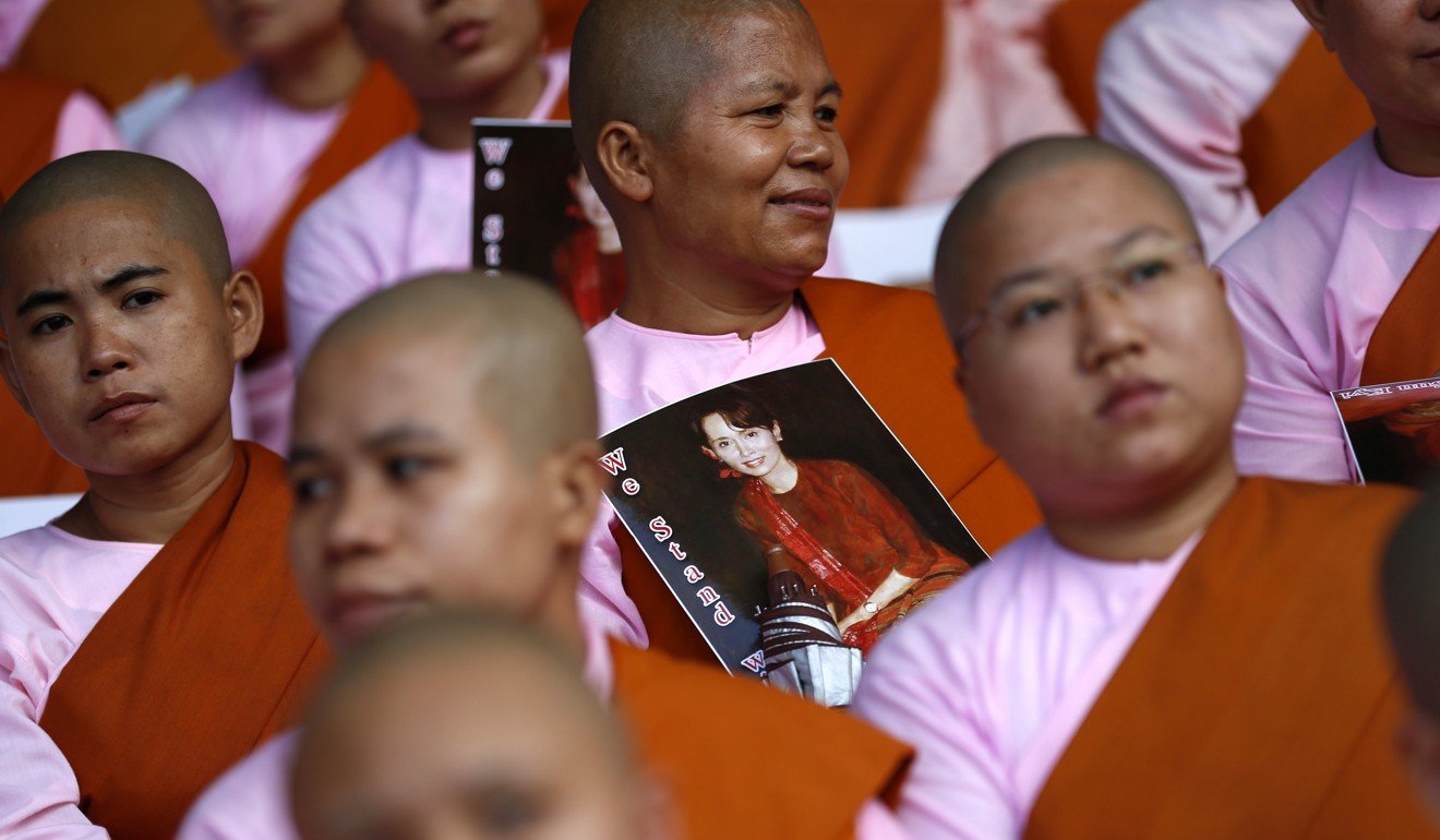 Buddhist nuns hold images of Aung San Suu Kyi at a prayer gathering in Yangon. Photo: EPA