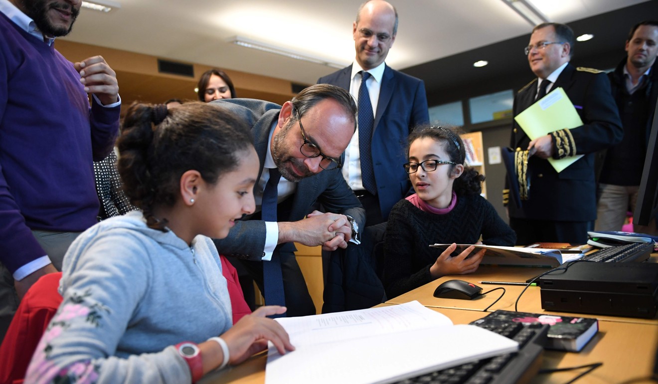 French Prime Minister Edouard Philippe speaks with pupils as he visits the Jean Perrin secondary school, flanked by French Education Minister Jean-Michel Blanquer. Blanquer has decried ‘repeated attacks on the French language’. Photo: AFP