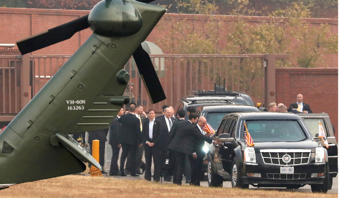 White House staff discuss the situation as Trump sits in his car after being grounded from an attempt to visit the Demilitarised Zone. Photo: Reuters