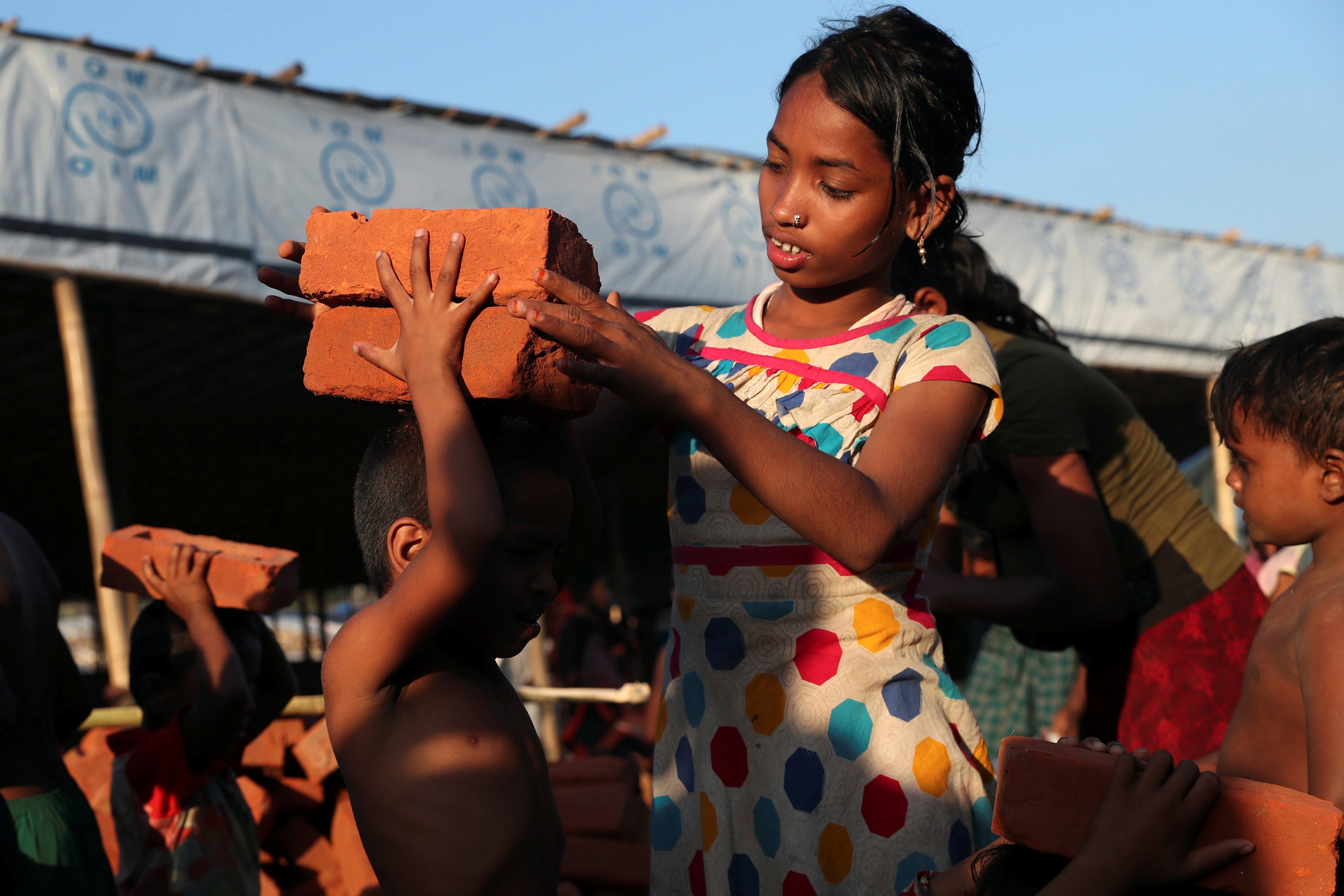 Rohingya refugee children collect bricks at the Balukhali Refugee Camp in Cox's Bazar, Bangladesh, on November 13. The UN’s International Organisation for Migration has warned that, with more than 600,000 Rohingya having fled Myanmar to Bangladesh since August, the refugees are at the mercy of human traffickers in the area. Photo: Reuters