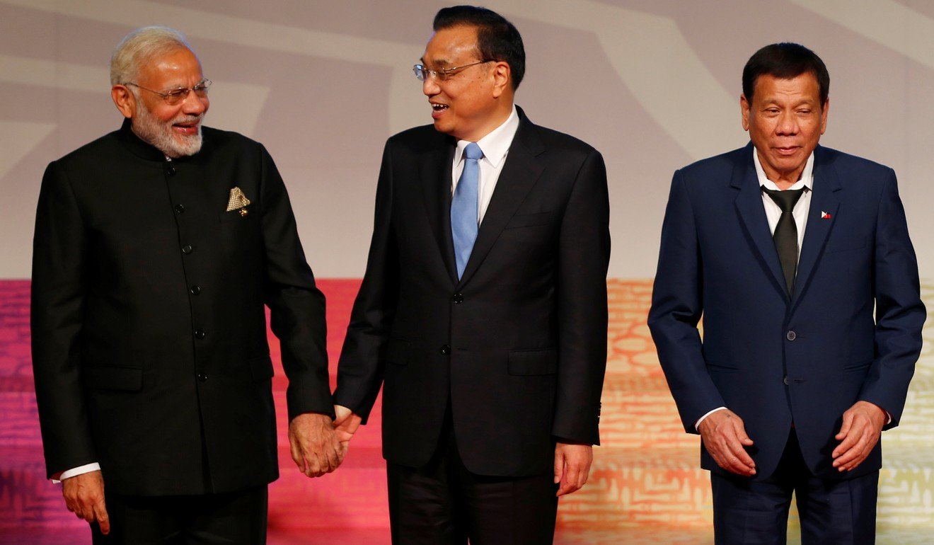Indian Prime Minister Narendra Modi and Chinese Premier Li Keqiang hold hands as Philippine President Rodrigo Duterte prepares to chair an East Asia Summit meeting in Manila on Tuesday. Photo: Reuters