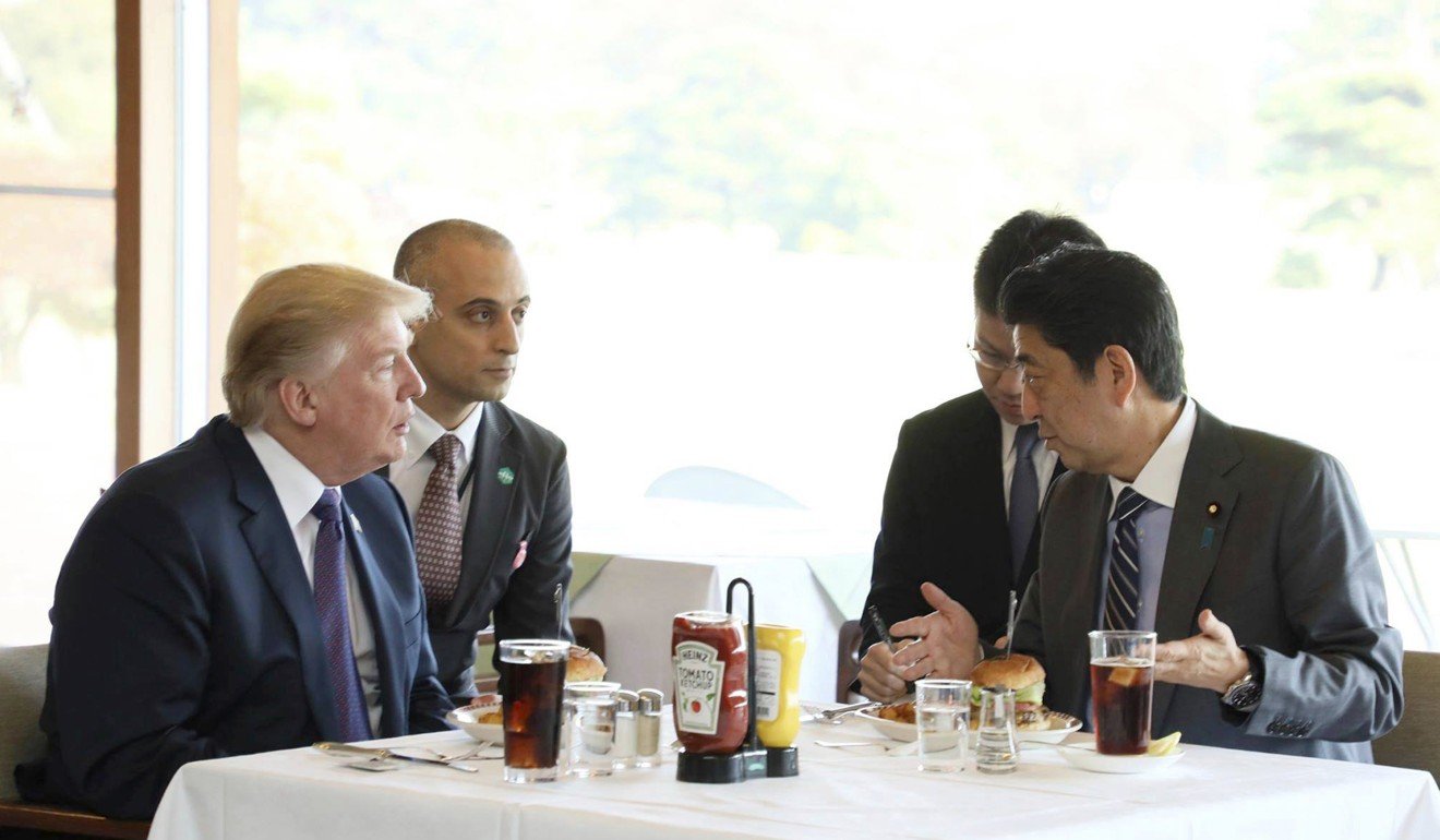 Trump and Japanese Prime Minister Shinzo Abe, right enjoy lunch of hamburgers from Munch's Burger Shack at Kasumigaseki Country Club. Photo: AP