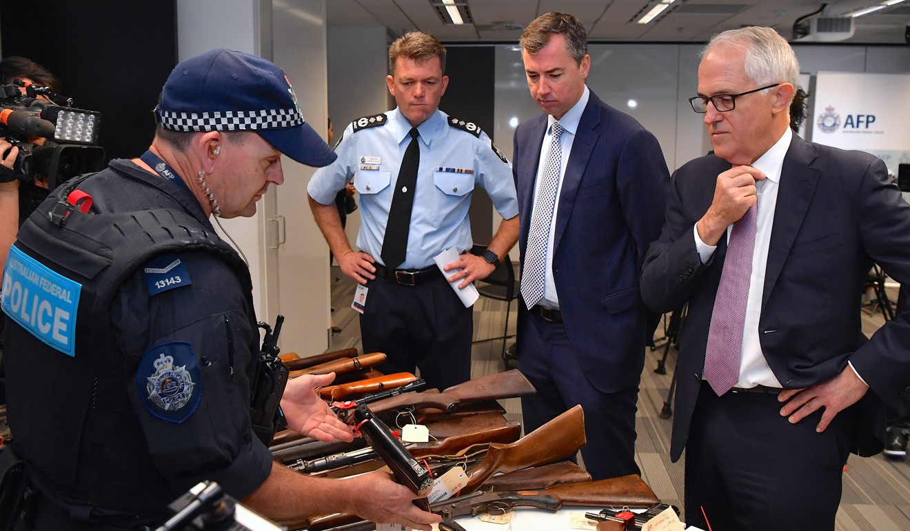 File photo of Australian Justice Minister Michael Keenan (second right) and Prime Minister Malcolm Turnbull looking at weapons handed in during an amnesty. Photo: Reuters