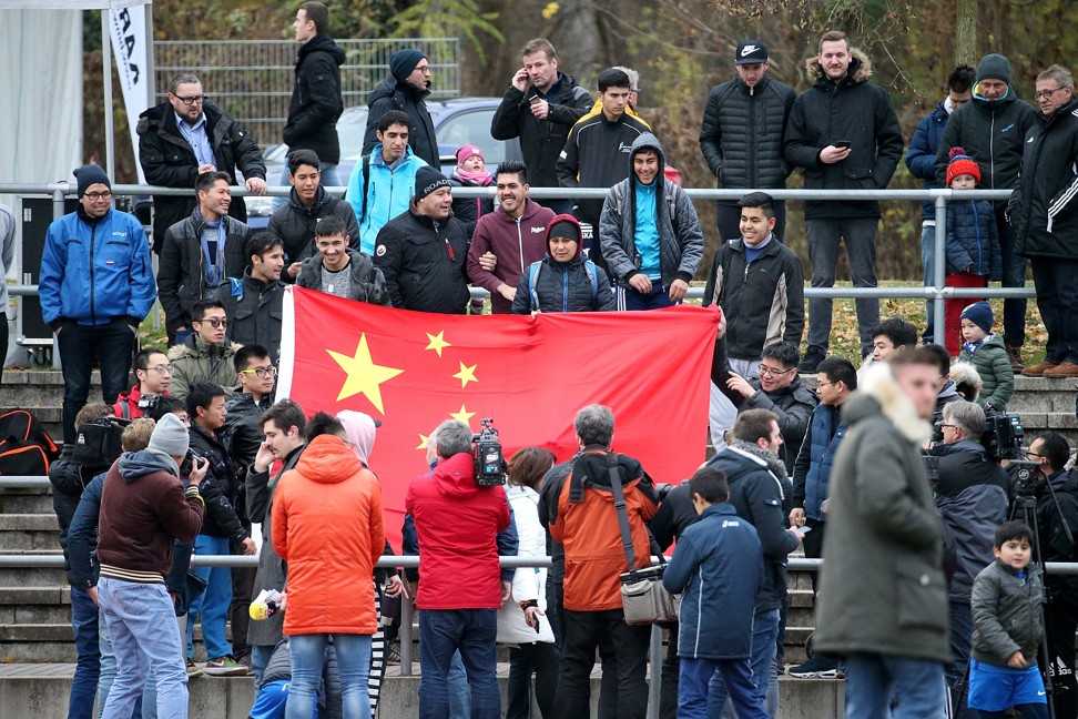 Chinese fans hold a Chinese flag during the friendly match between fourth division team Schott-Mainz and the U20 national squad of China. Photo: AP