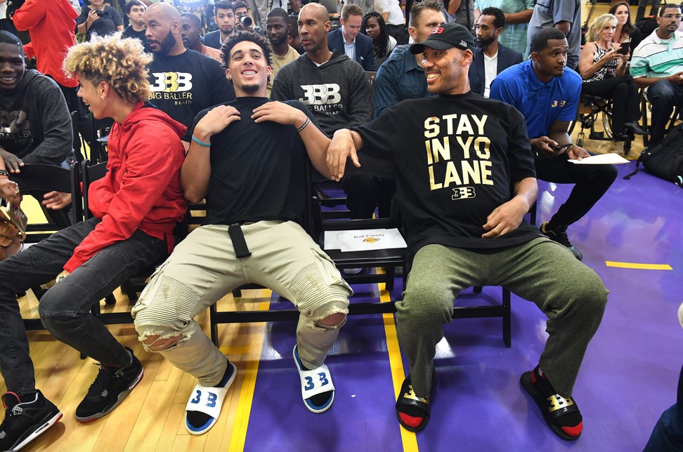 LaVar Ball sits with his sons LaMelo (L) and LiAngelo (C). Photo: TNS
