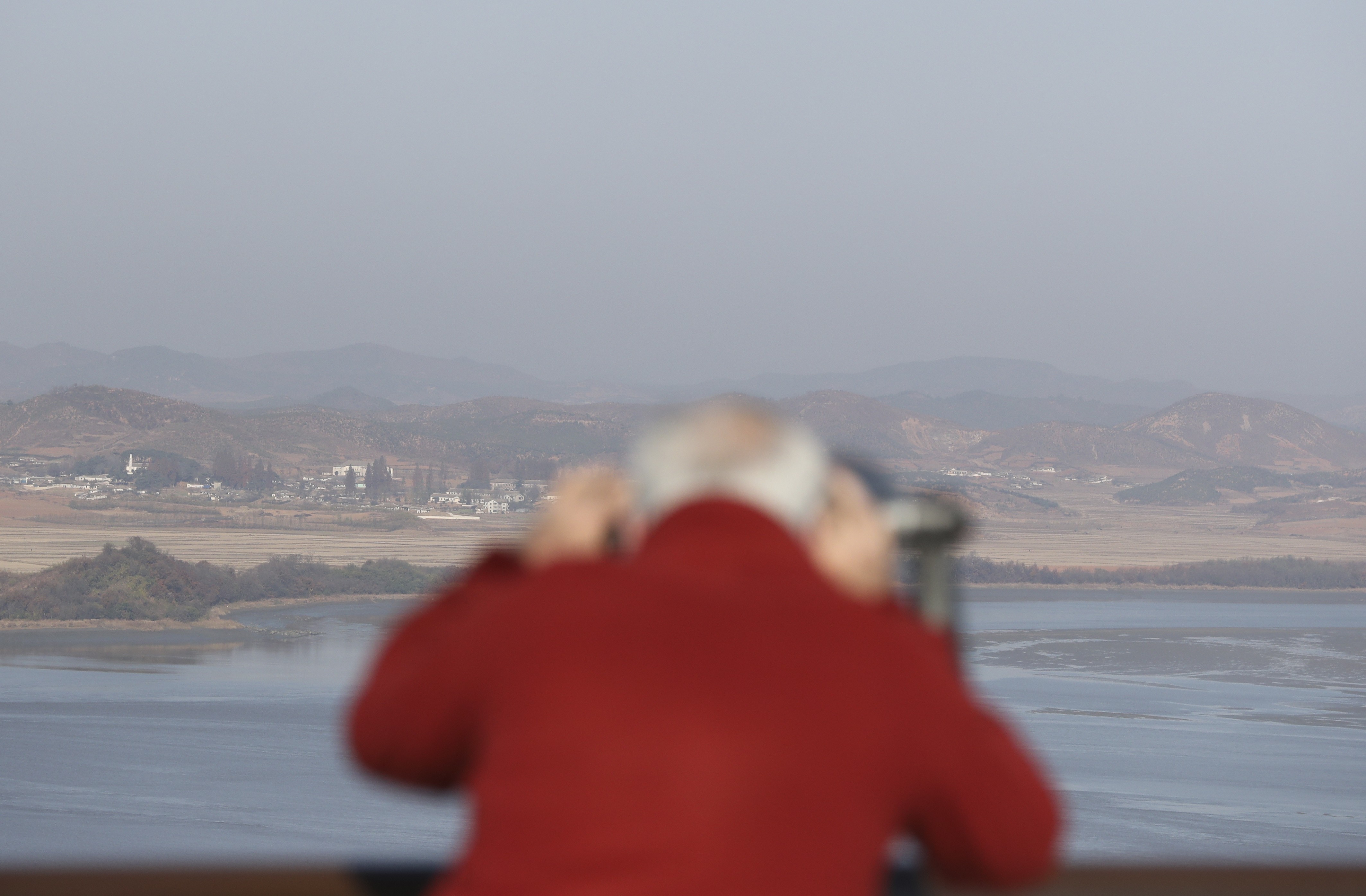 A man looks at North Korea through binoculars from the unification observatory in Paju, South Korea, on November 14. Russia is proposing a three-phase road map for peace, supported by the Chinese. Photo: AP