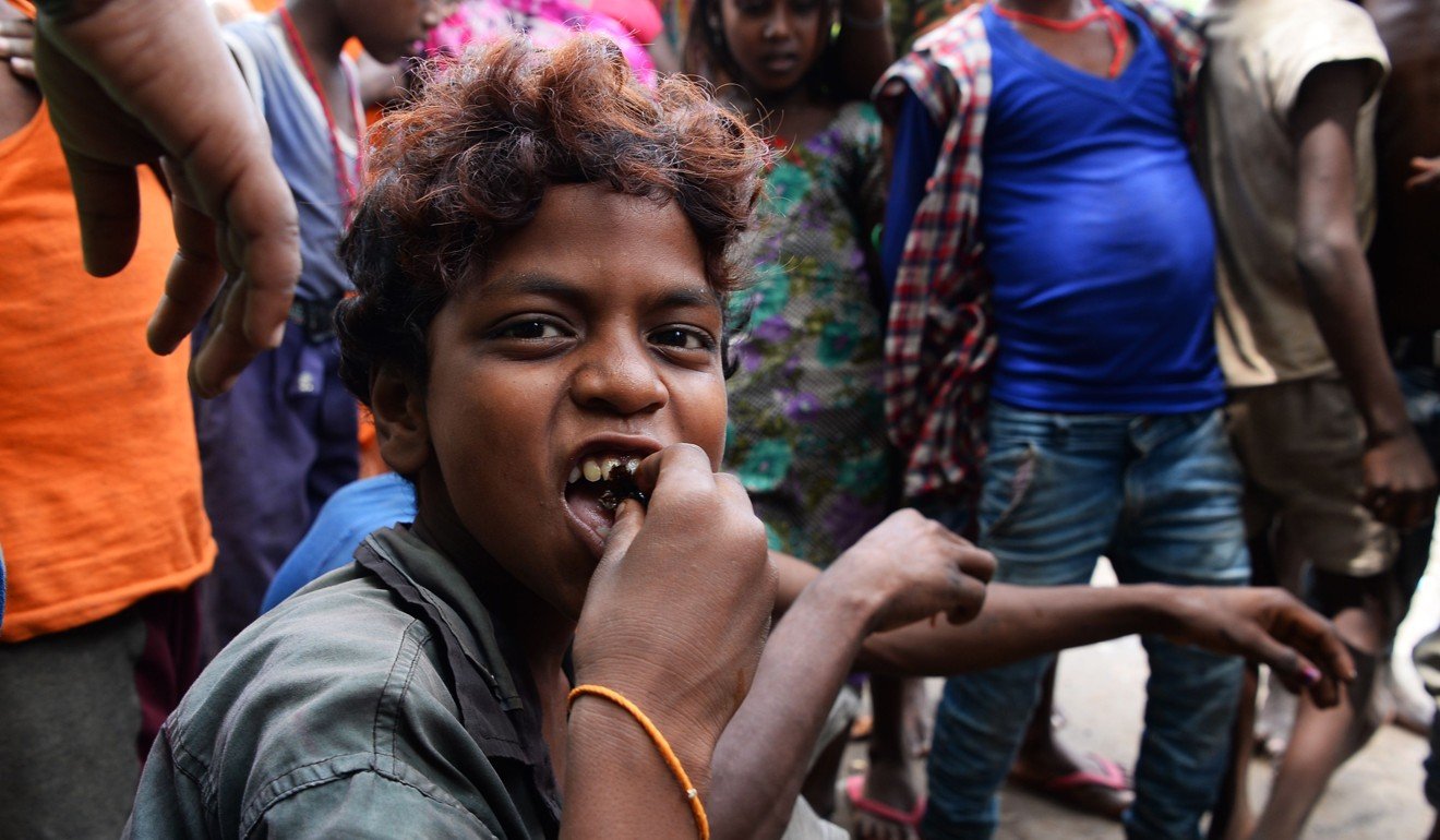 A boy eats roasted rat. Photo: AFP