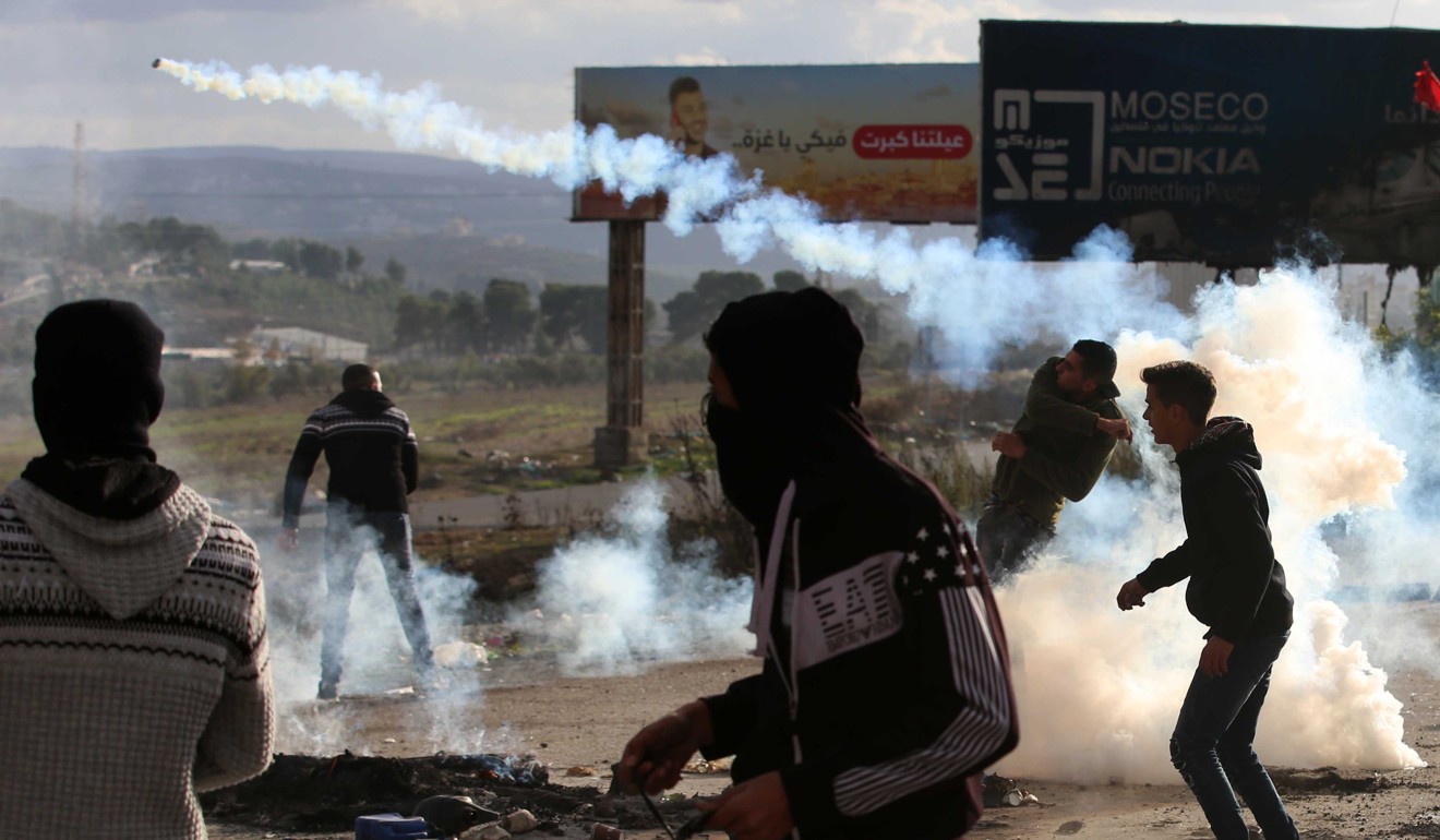 A Palestinian protester throws back a tear gas canister at Israeli soldiers during clashes in the West Bank city of Nablus. Photo: Xinhua