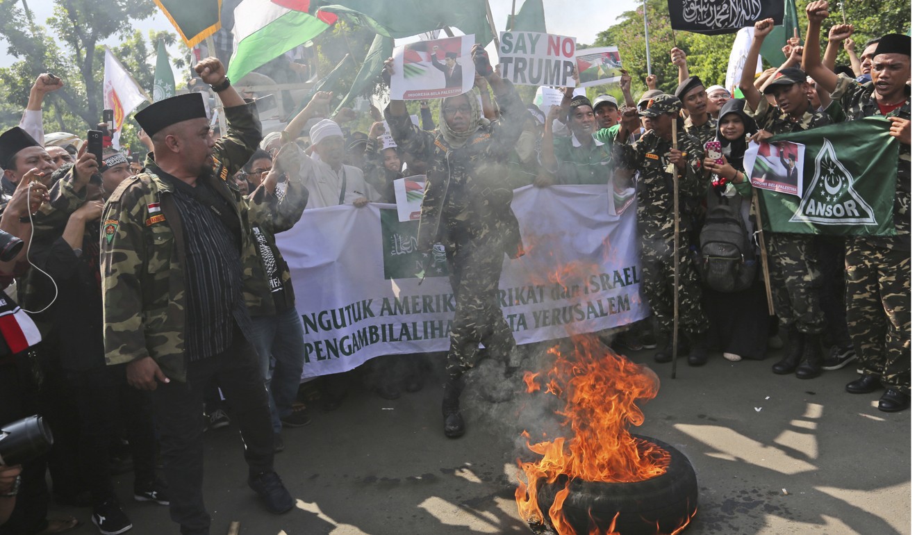 Muslim men burn a tyre outside the U.S. Embassy in Jakarta. Photo: AP